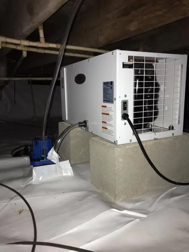 An air conditioning unit installed in an attic space, with visible ductwork and wiring.