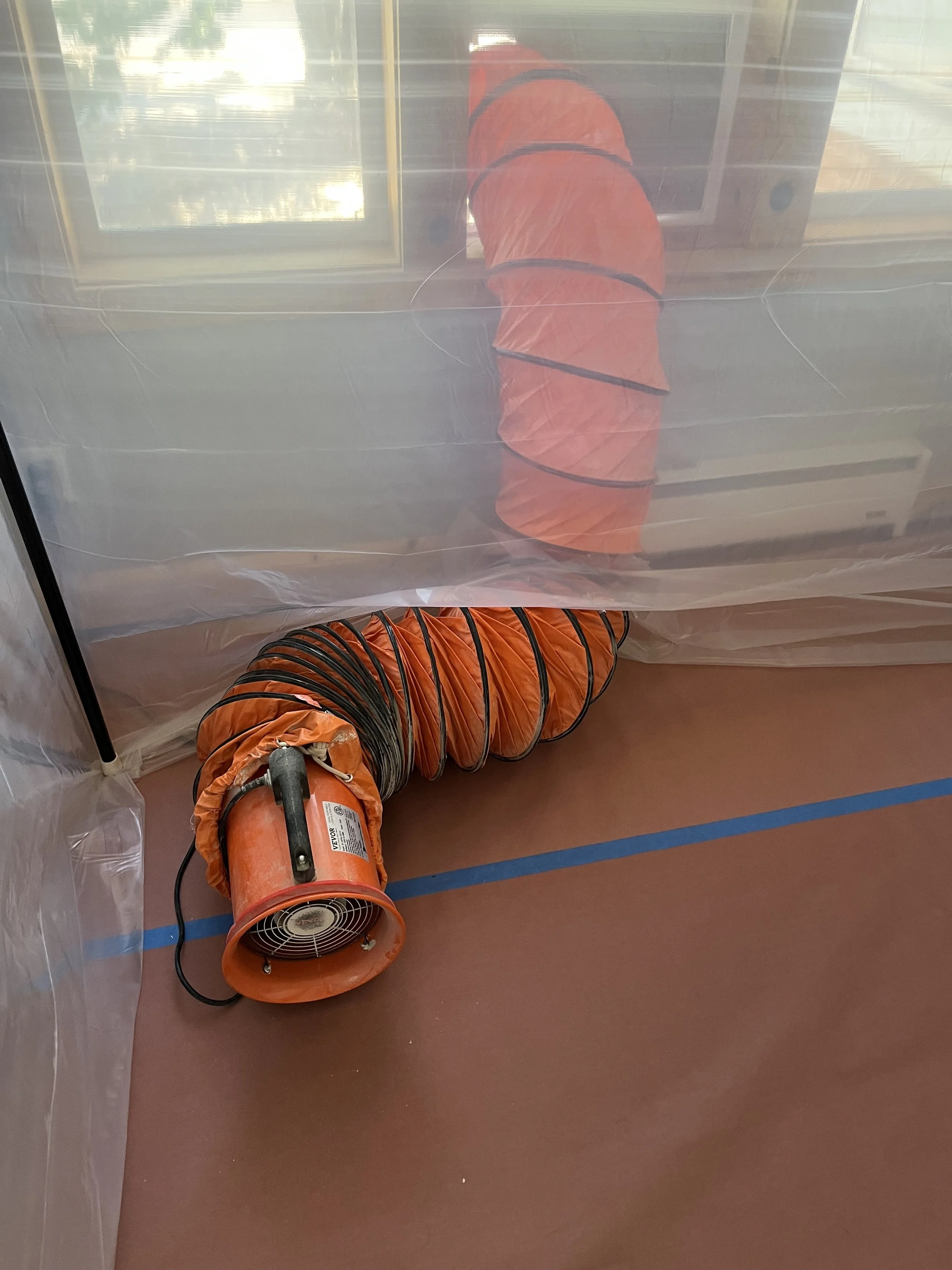 High powered dust exhaust fan ducted through a window to remove dust from the room. Plastic temporary dust barrier to limit dust. Floor protection to prevent damage from remodeling