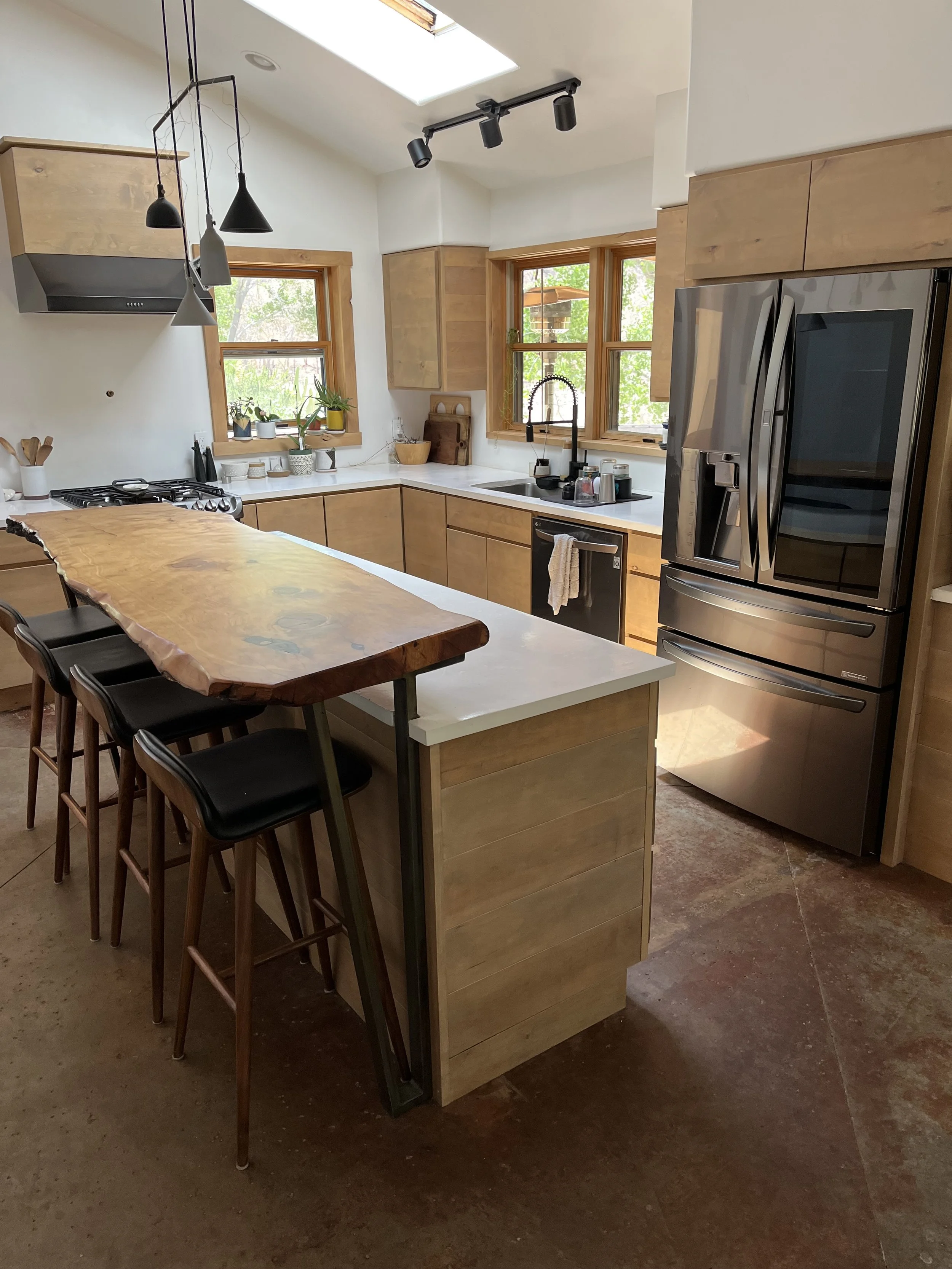 Custom kitchen cabinetry with live edge slab countertop and custom steel support brackets. Modern design with organic accents