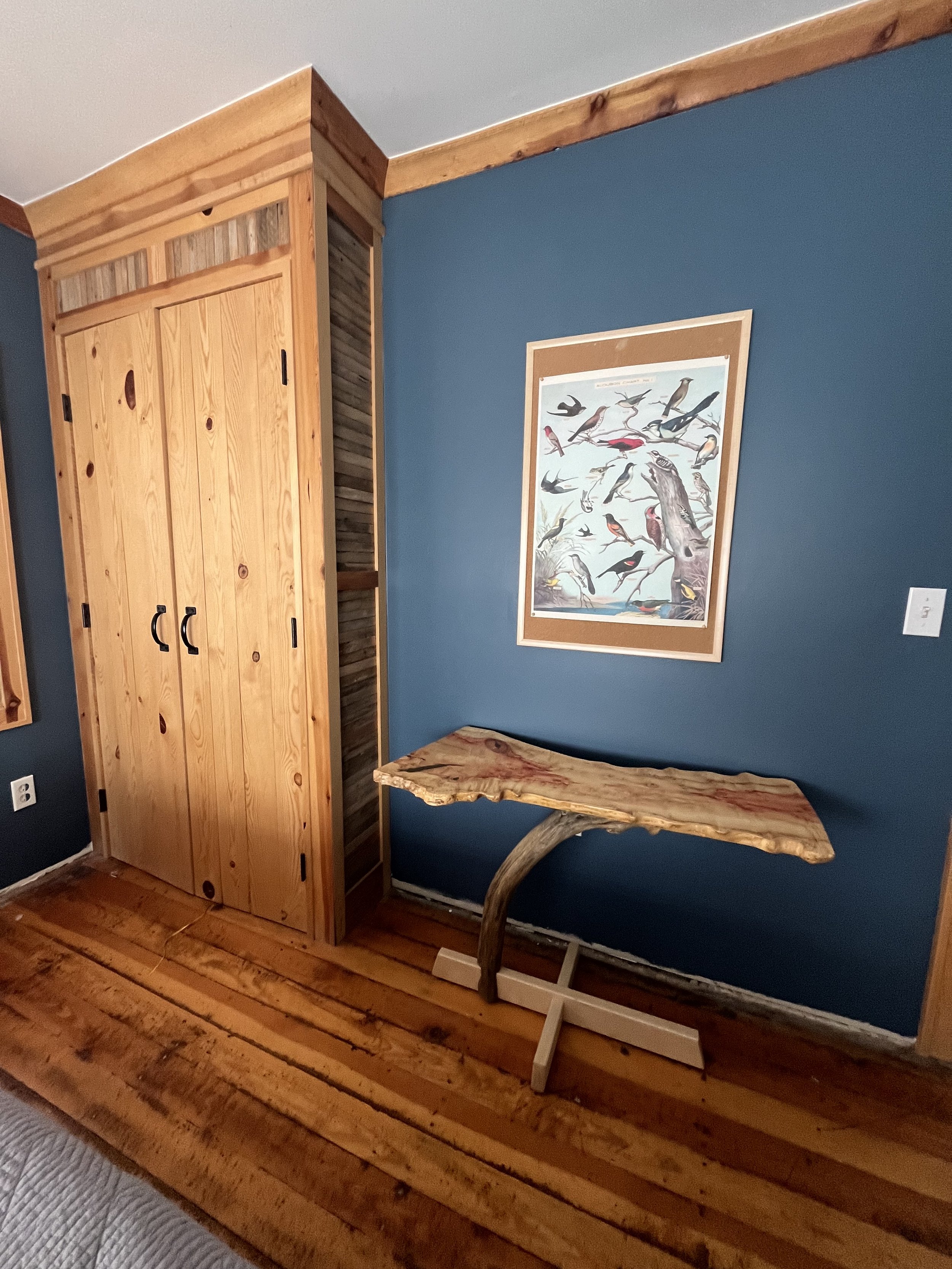 A wooden bed frame headboard made from a large, live-edge slab of wood with a natural finish.