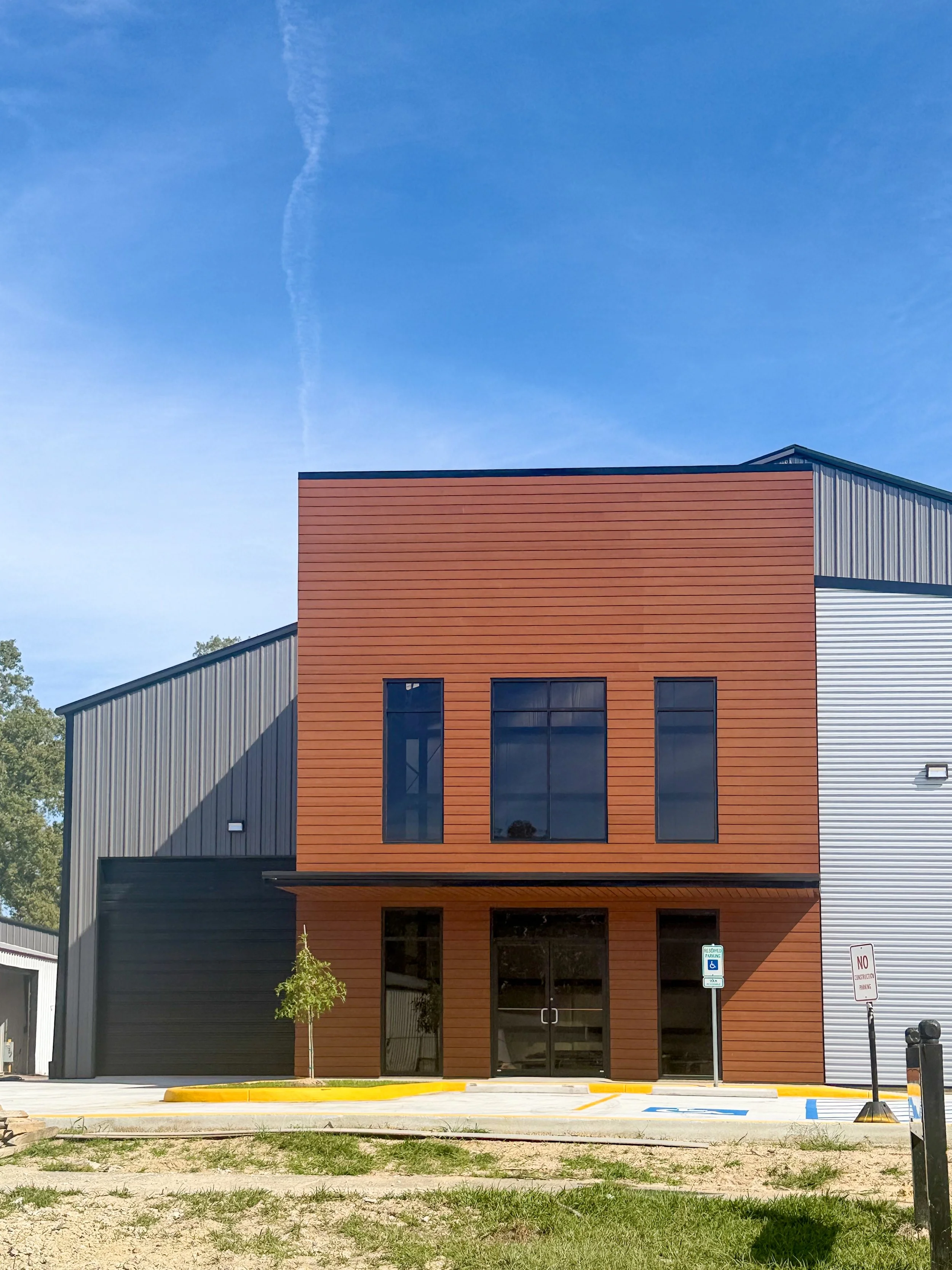 Modern commercial metal office building with wood-tone exterior accents and custom steel construction by B&J Metal Buildings LLC.