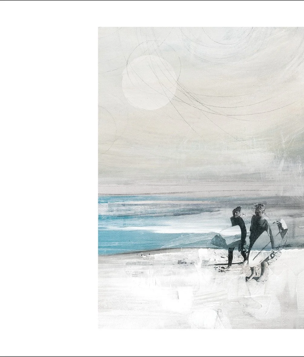 Two surfers with surfboards walking along the beach.