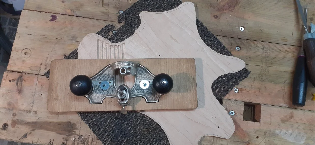 Using the Stanley No. 71 router plane to cut channels in the underside of the maple top. This was supposed to make it easier to bend over the forearm contour. I made a bit of a mess of this, but it didn't matter as it's on the underside.