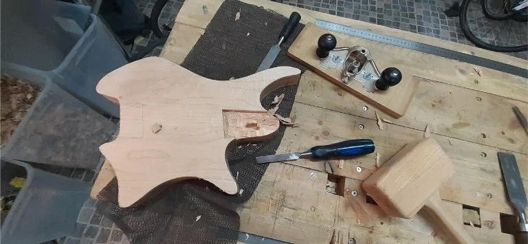 Chopping out the neck pocket the old fashioned way with chisels and router plane. For a one off job this is much quicker than making a template for the power router.
