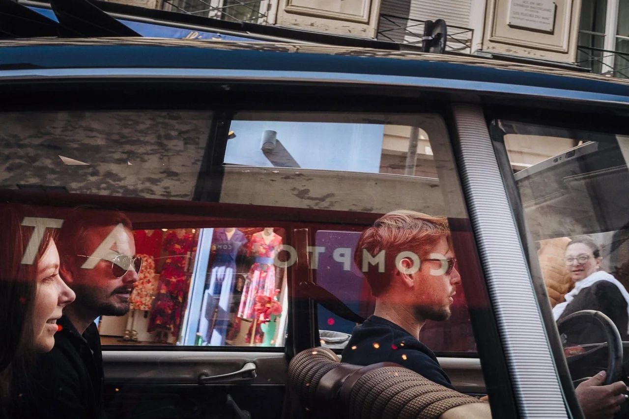Couple driven in the back of a car through Paris