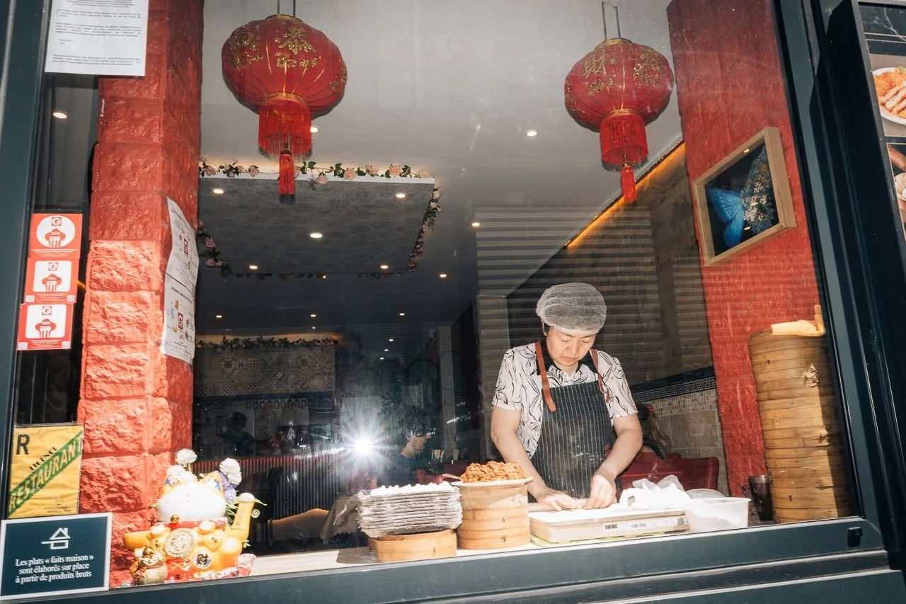 Asian woman preparing food in an asian restaurant in Paris, France