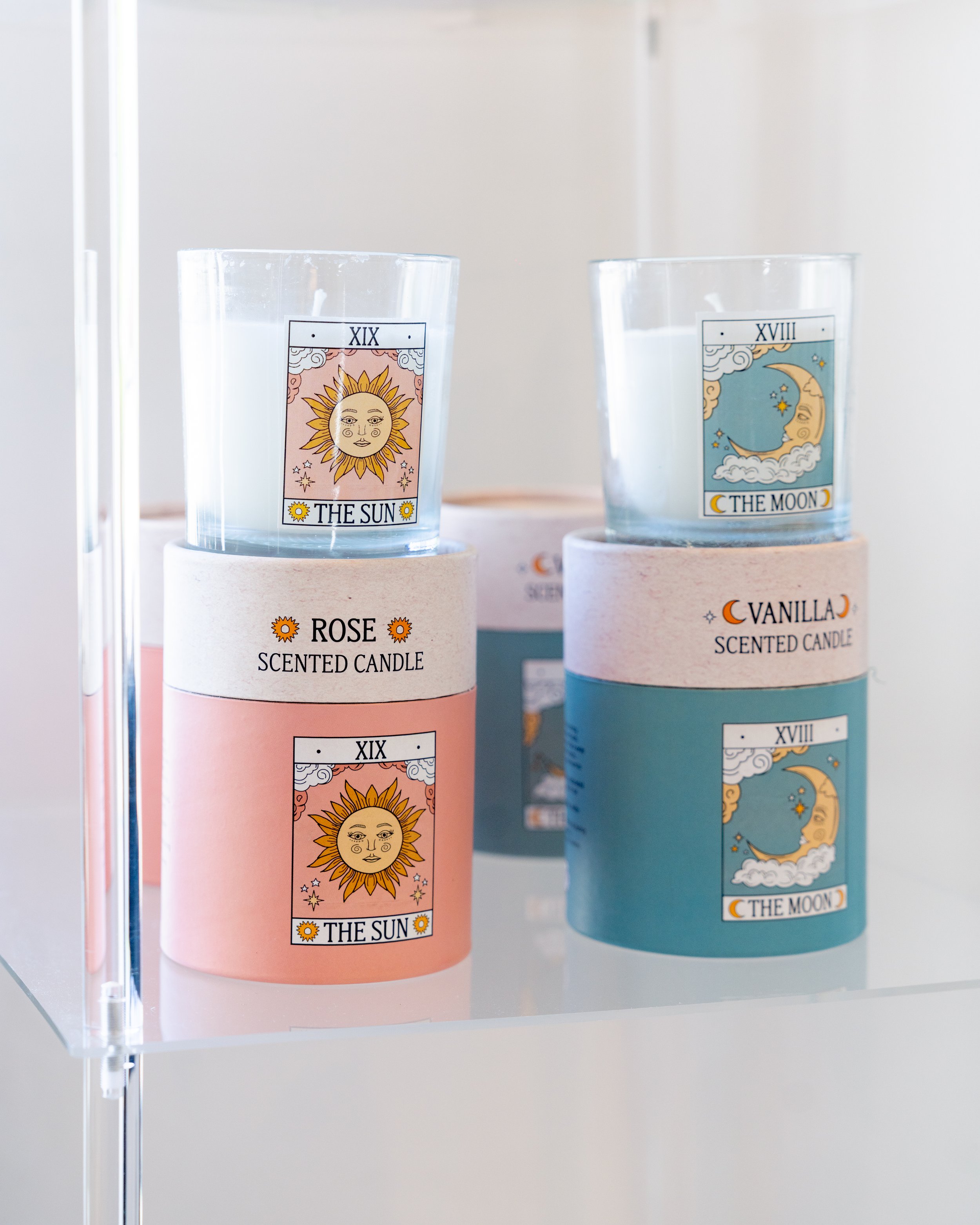 Two candles labeled 'The Sun' and 'The Moon', each in a decorative holder with matching packaging.