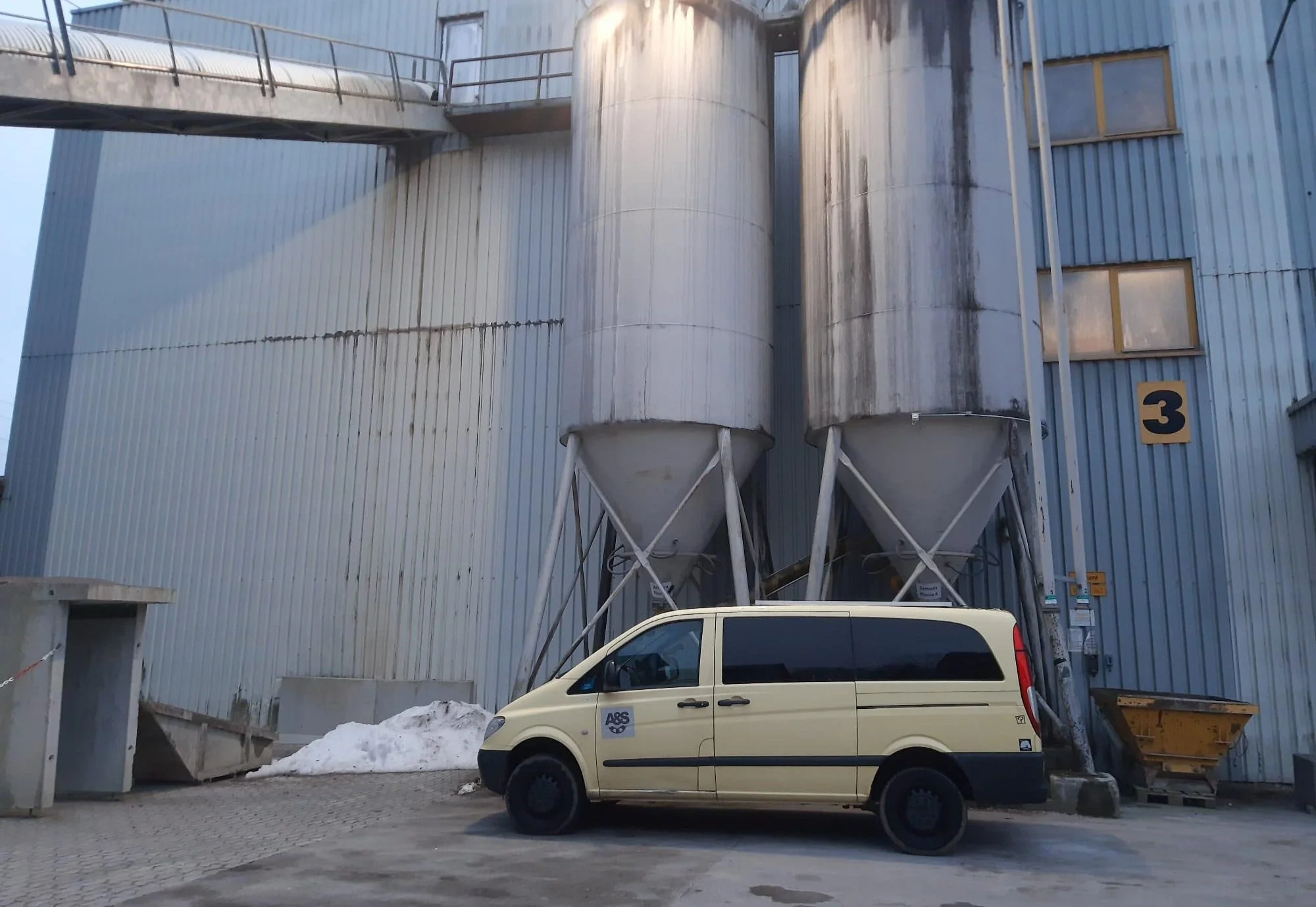 Silos und Firmenfahrzeug der A&S Jordi GmbH vor einem Betonwerk