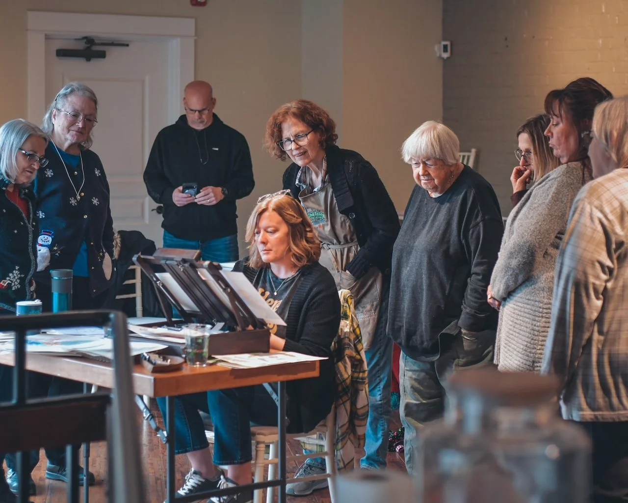 students gathered around an artist as she paints
