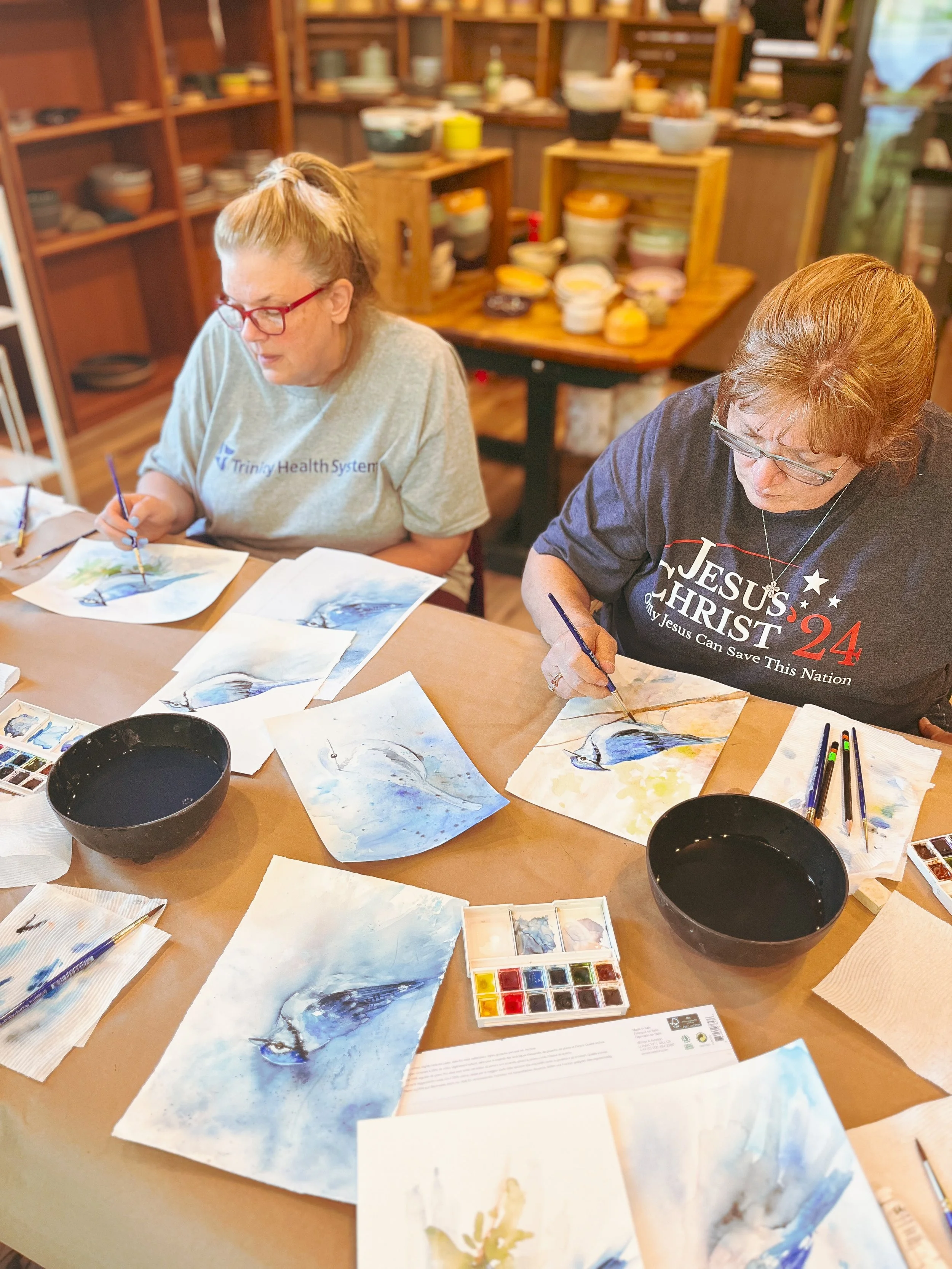 a group of students painting blue jays in watercolor
