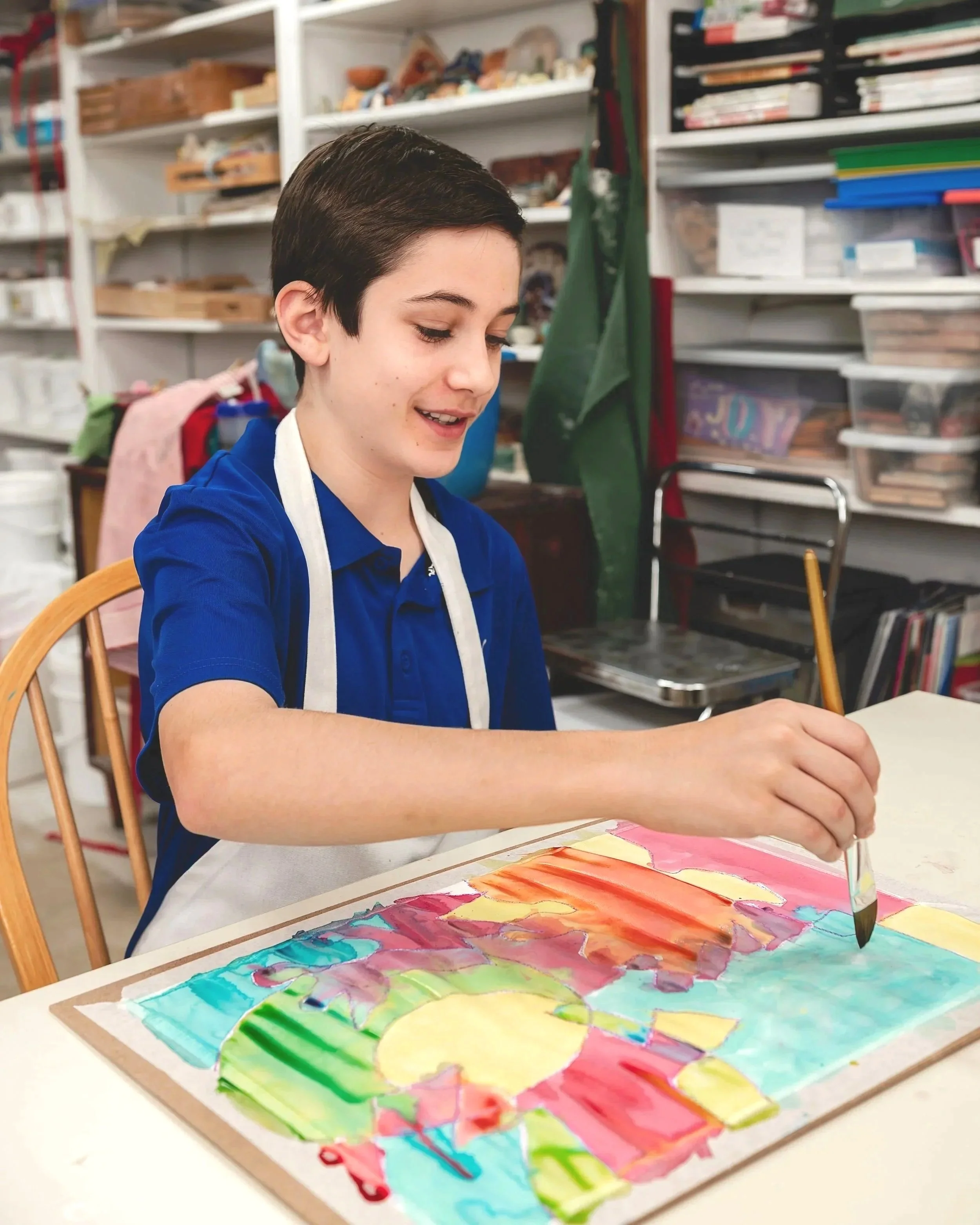 Student making a water color painting in Fairmount's visual art studio