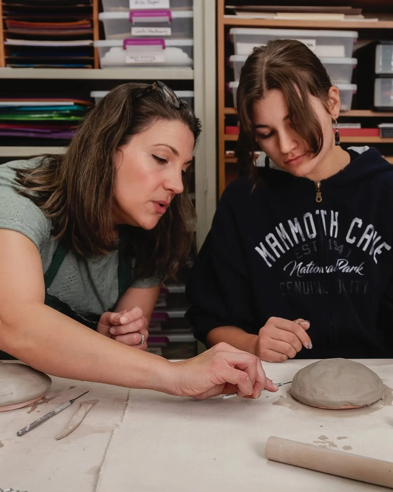 Art Instructor Assisting Student with Ceramics Project