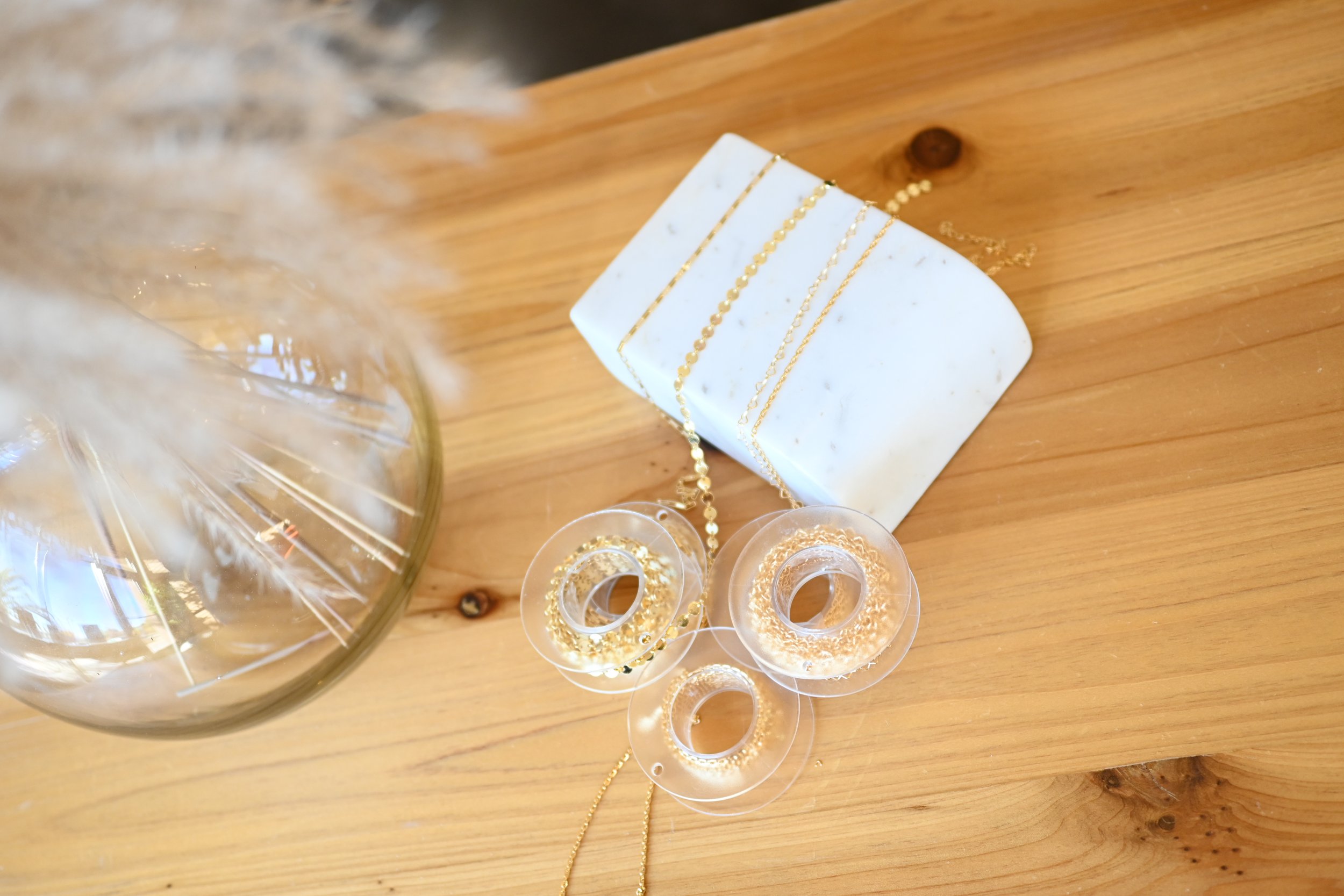 Gold permanent jewelry chains displayed at a MIKU Jewelry pop-up in Frederick, MD