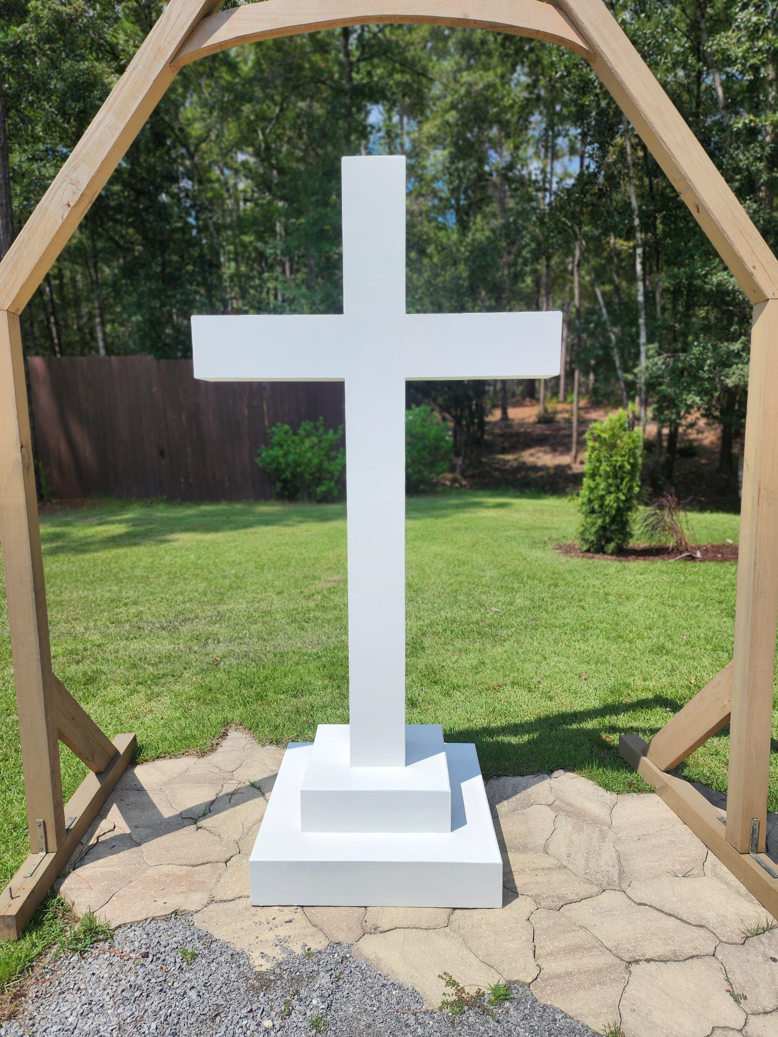 Large white cross altar and cathedral window altar for wedding ceremony.