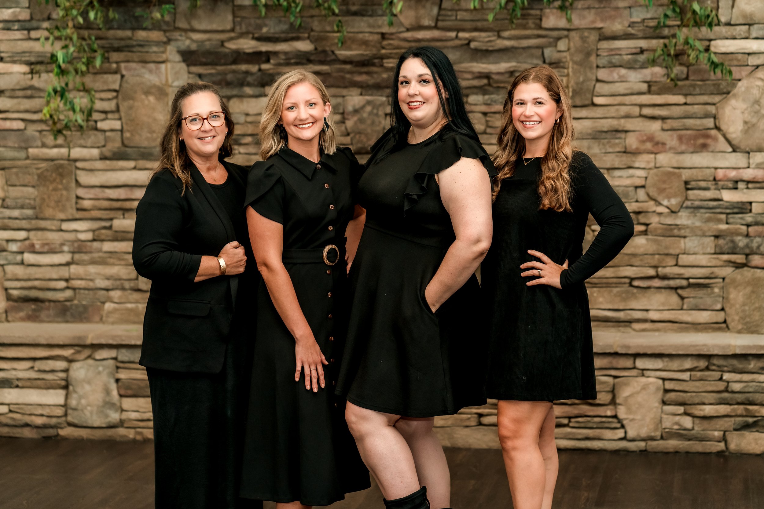 wedding planners in front of a large stone fireplace.