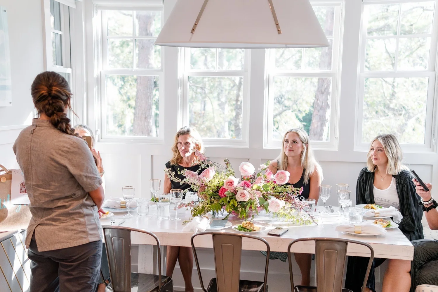 Guests at a flower-filled table during a private chef afternoon on 30A