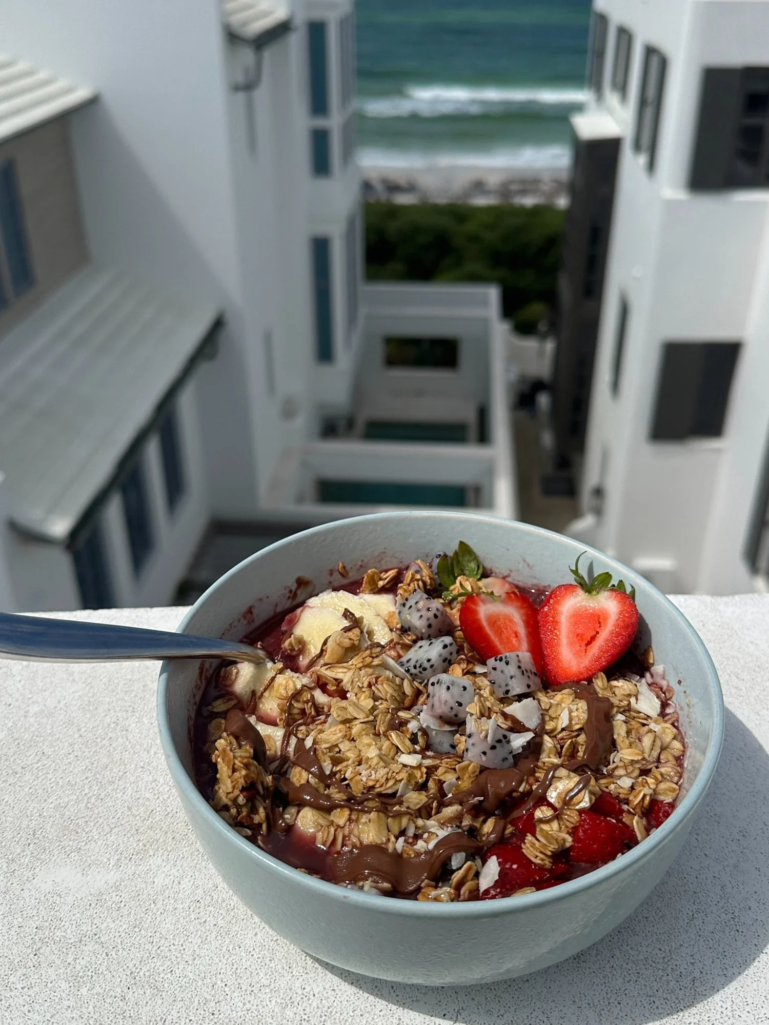Açaí parfait bowl with strawberries on a balcony overlooking the Gulf