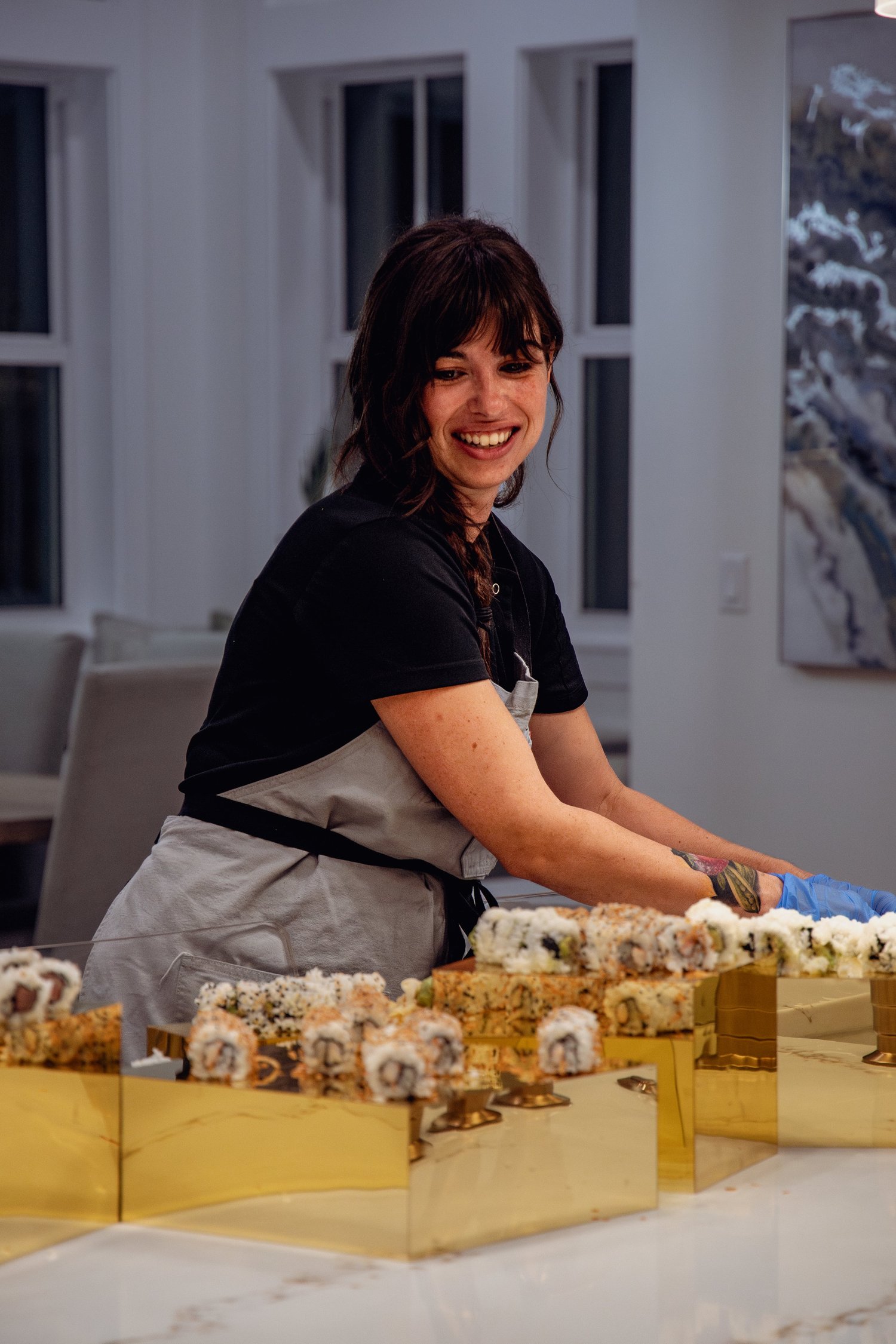 Chef Jojo smiling behind a gold tray of sushi she rolled for a bachelorette dinner on 30A
