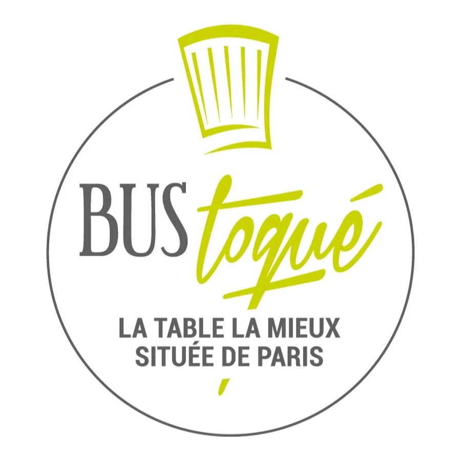 Logo du restaurant Bus Toqué avec un chef stylisé en haut, le nom du restaurant en écriture moderne et la mention "la table la mieux située de Paris" en dessous.