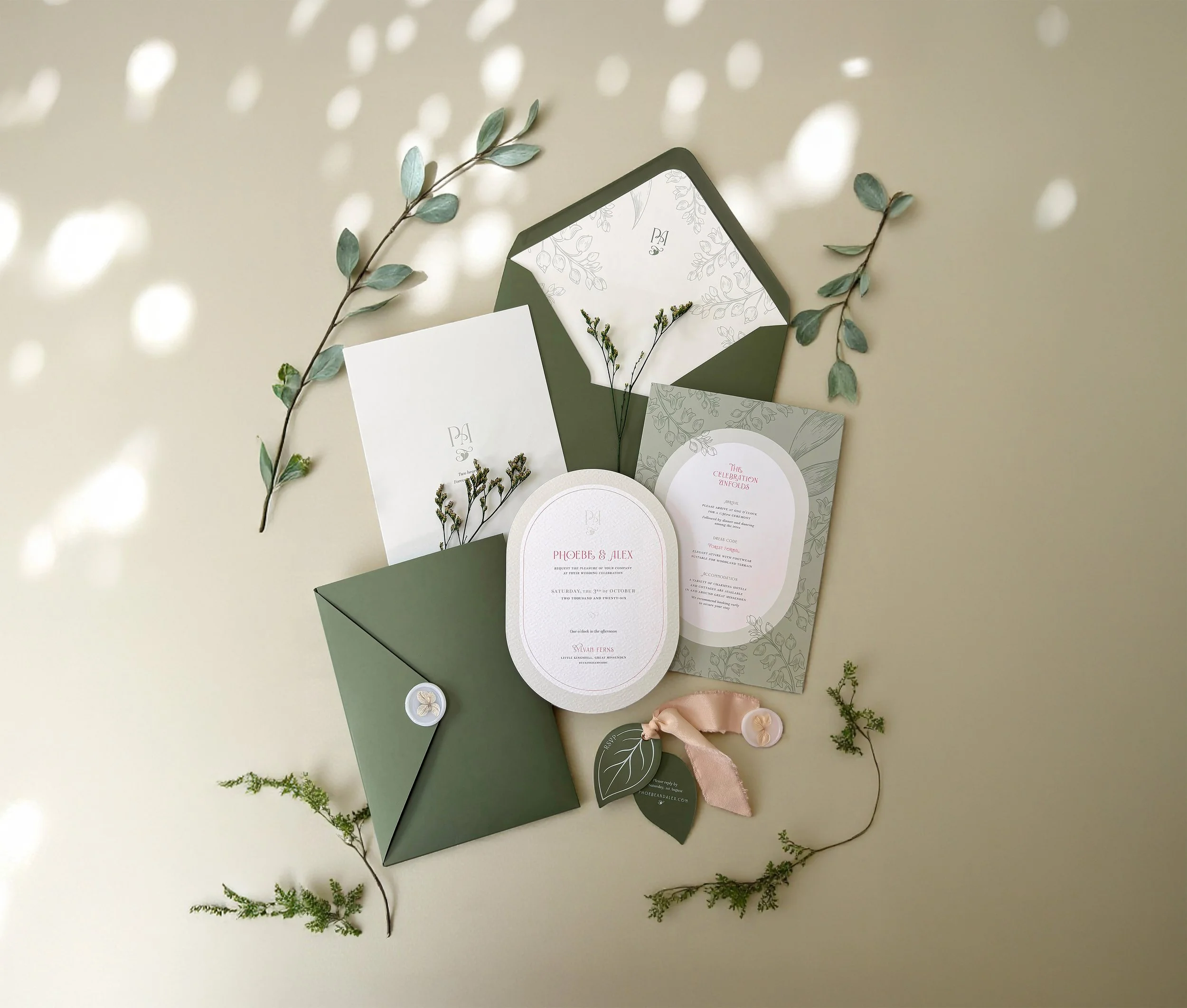 An elegant wedding invitation suite with green pocket-fold wallet, die cut RSVP leaf, botanical styling, silk ribbon tie, textured stock and wax seal. From the Ever Entwined wedding stationery collection by Honey Bee Mine.