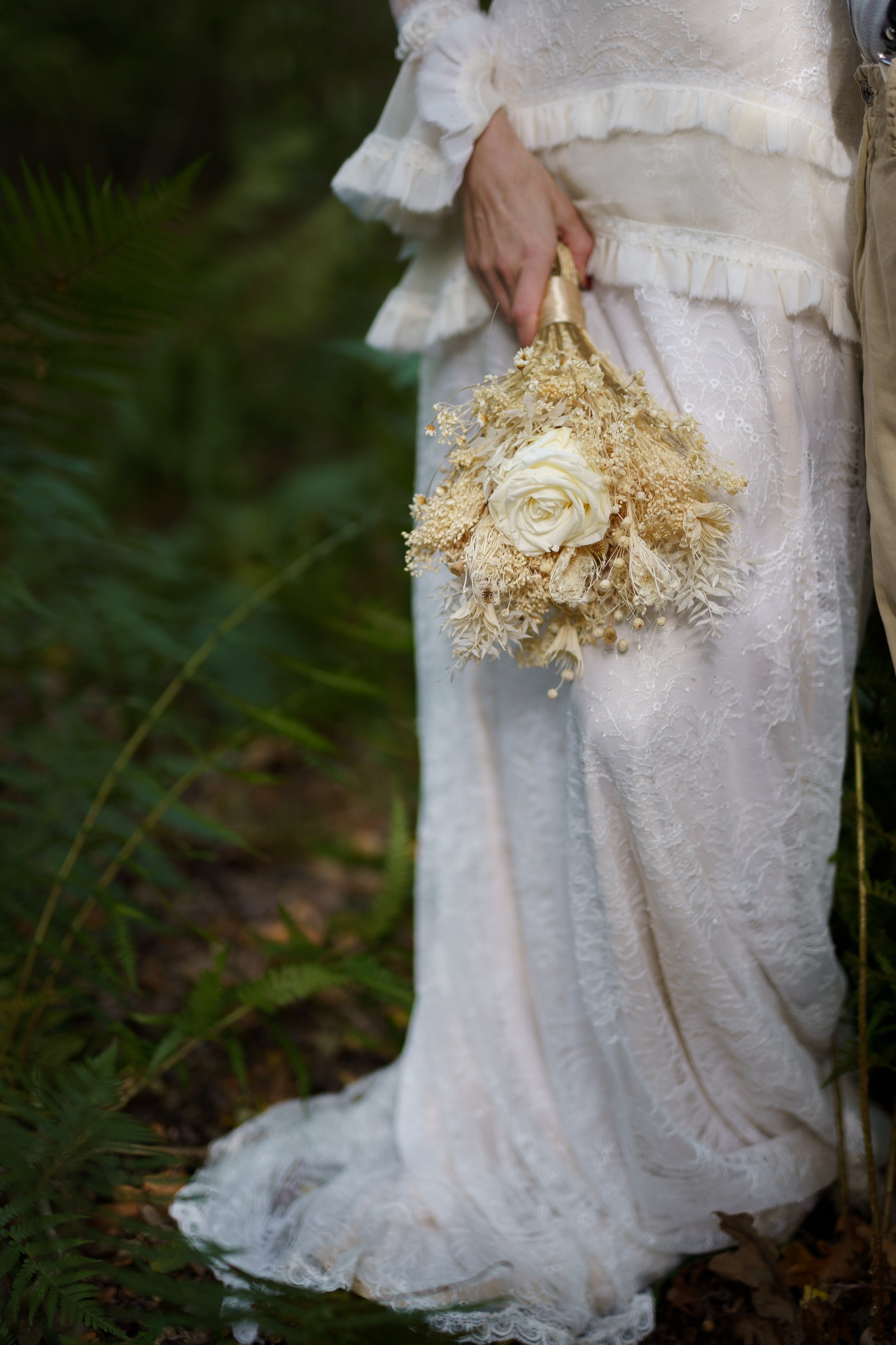 Bride holding bouquet in woodland at Sylvan Ferns during an intimate wedding editorial.
