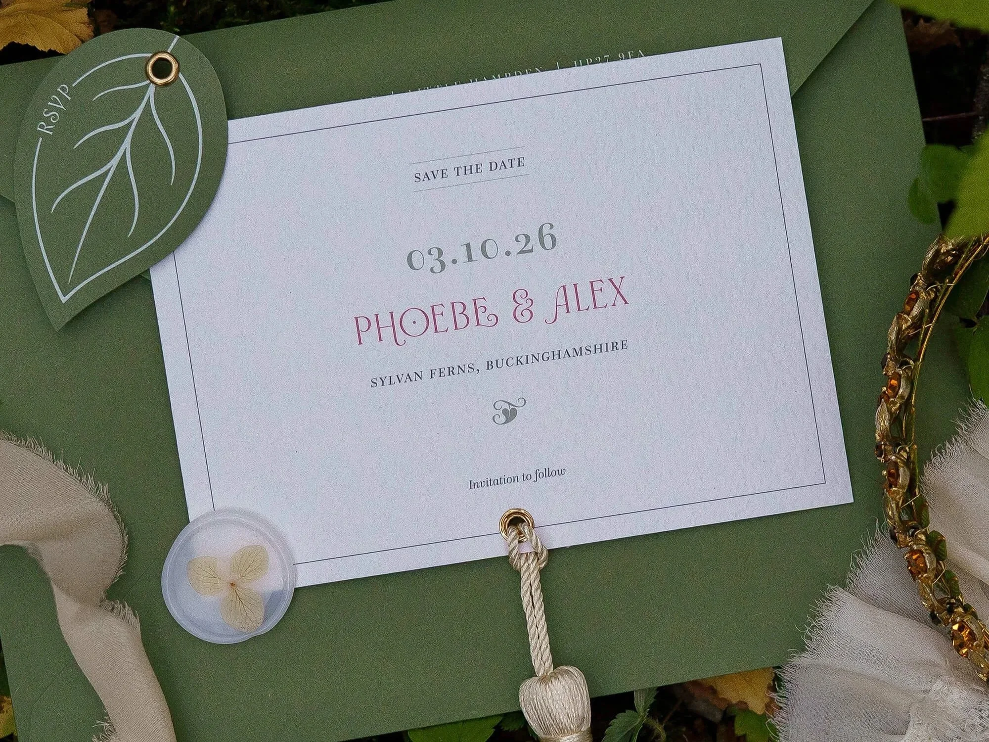 Luxury ivory and forest green wedding invitation suite with botanical details and die-cut shapes.