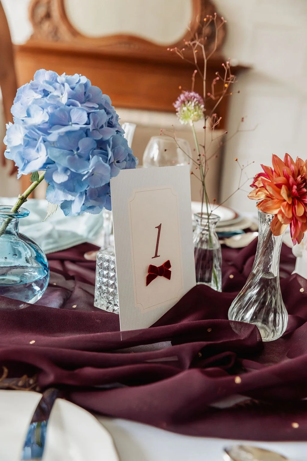 Luxury wedding table number in ivory and powder blue, adorned with burgundy bow. Stationery designed by Carrie at Honey Bee Mine, and captured in the Scottish Highlands.
