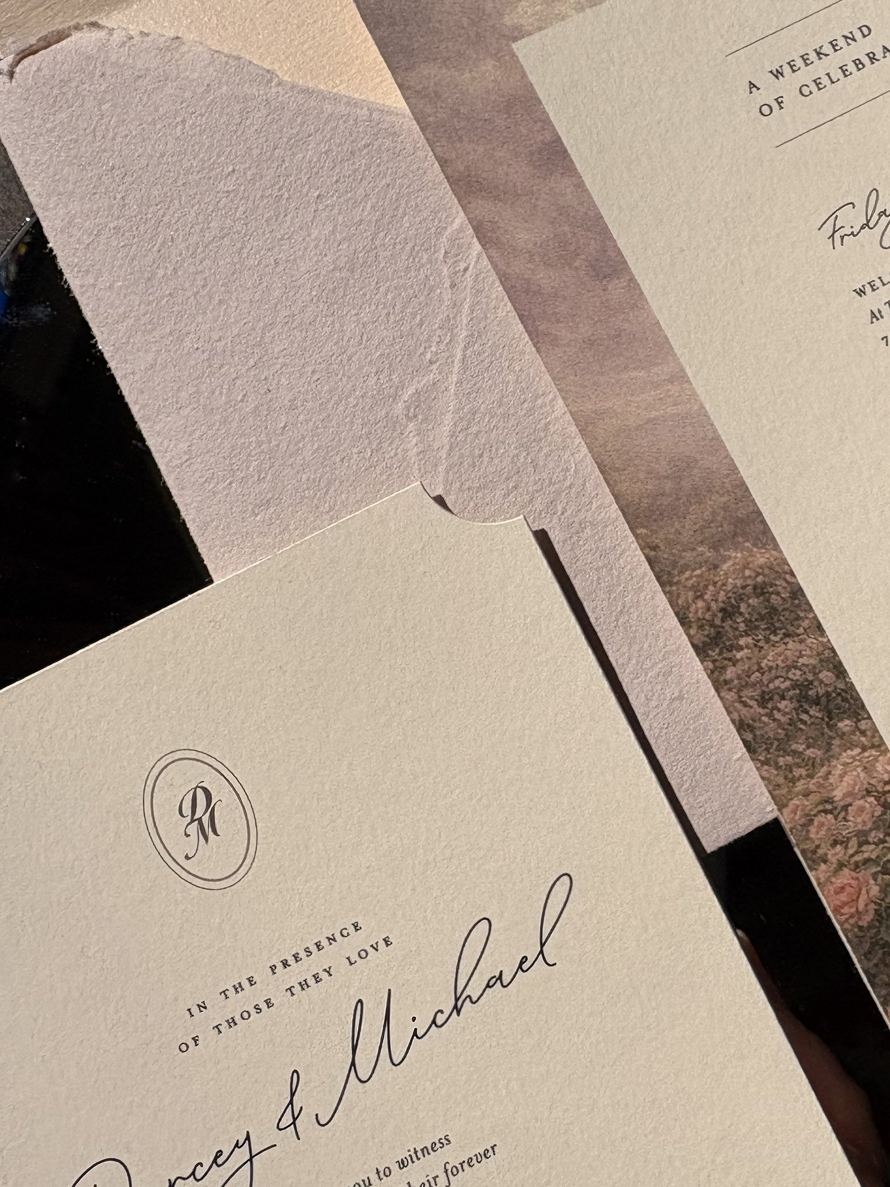 Close-up of rose and ivory wedding invitations with vintage-style ribbon at Arley Hall & Gardens.