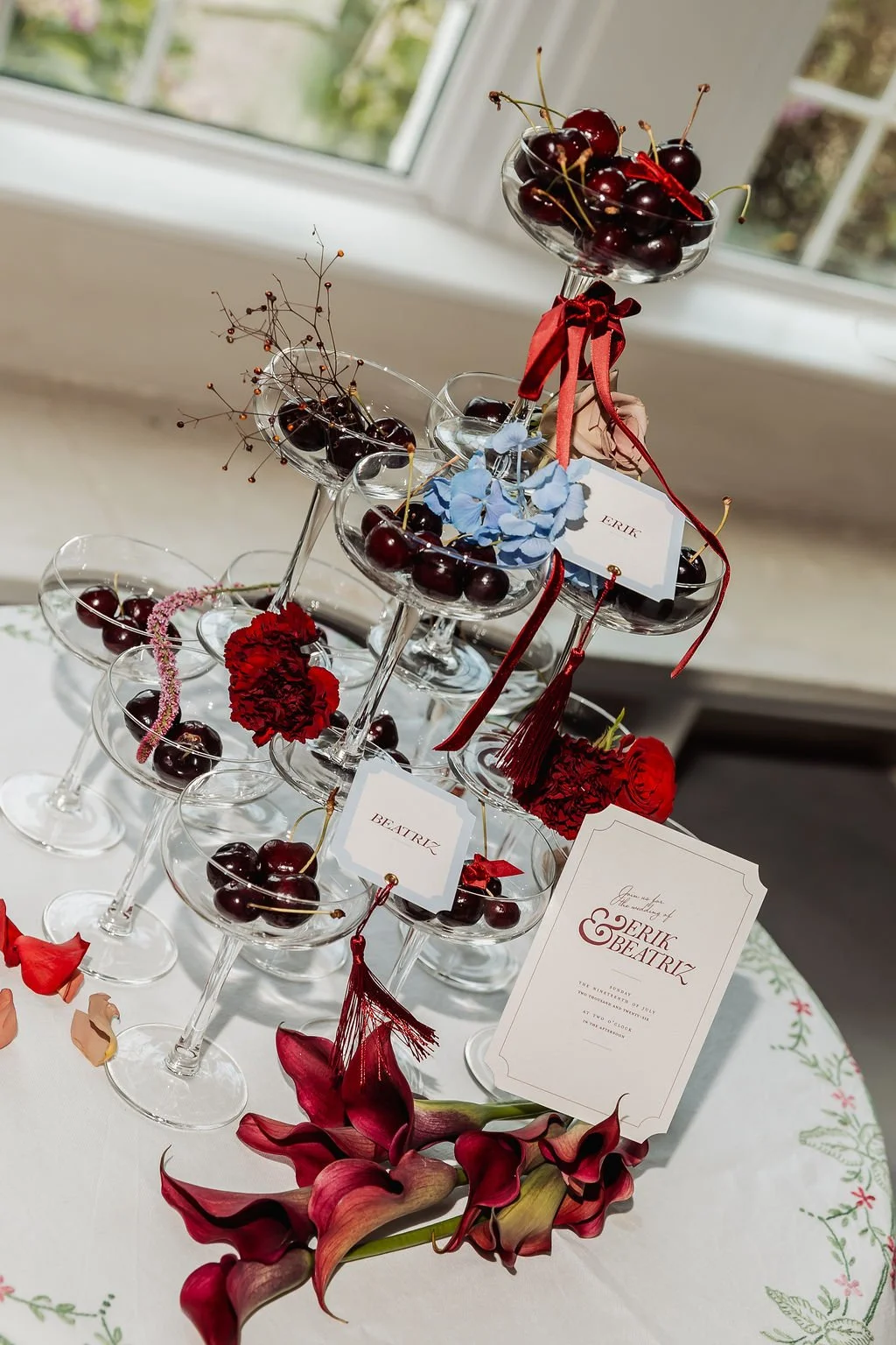 Luxury wedding invitation suite with vintages florals, powder blue and burgundy tones, velvet ribbon and tassels, styled alongside a cherry champagne tower. Stationery designed by Carrie at Honey Bee Mine, and captured in the Scottish Highlands.