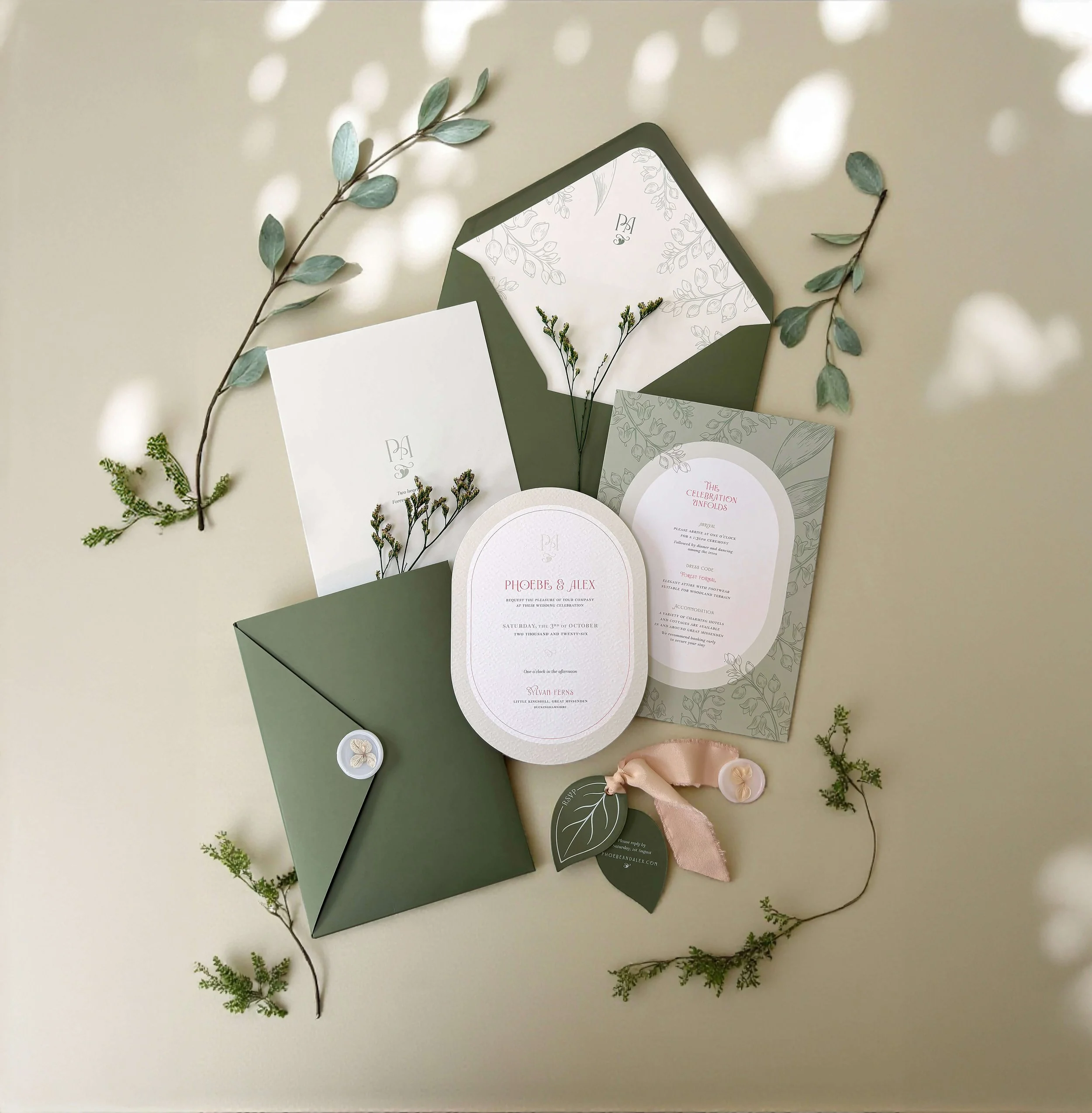 Botanical wedding invitation suite showing pocket-fold wrap with monogram, wax seal. Oval die-cuts and textured card stocks create a luxurious suite, with silk ribbon detailing and die-cut leaves. From the Ever Entwined wedding stationery collection 