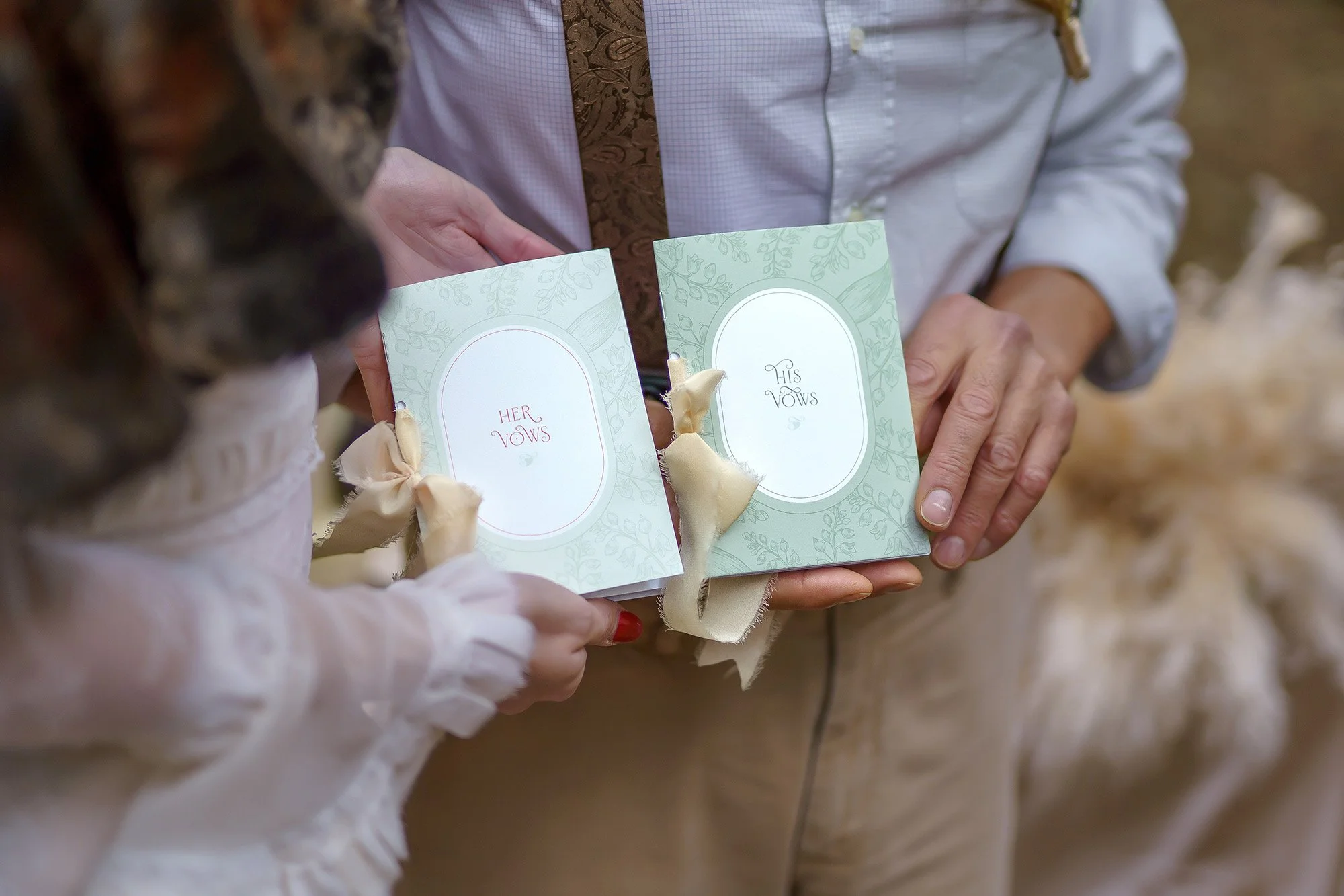 Bride and groom holding Ever Entwined wedding stationery vow books during a woodland wedding editorial.