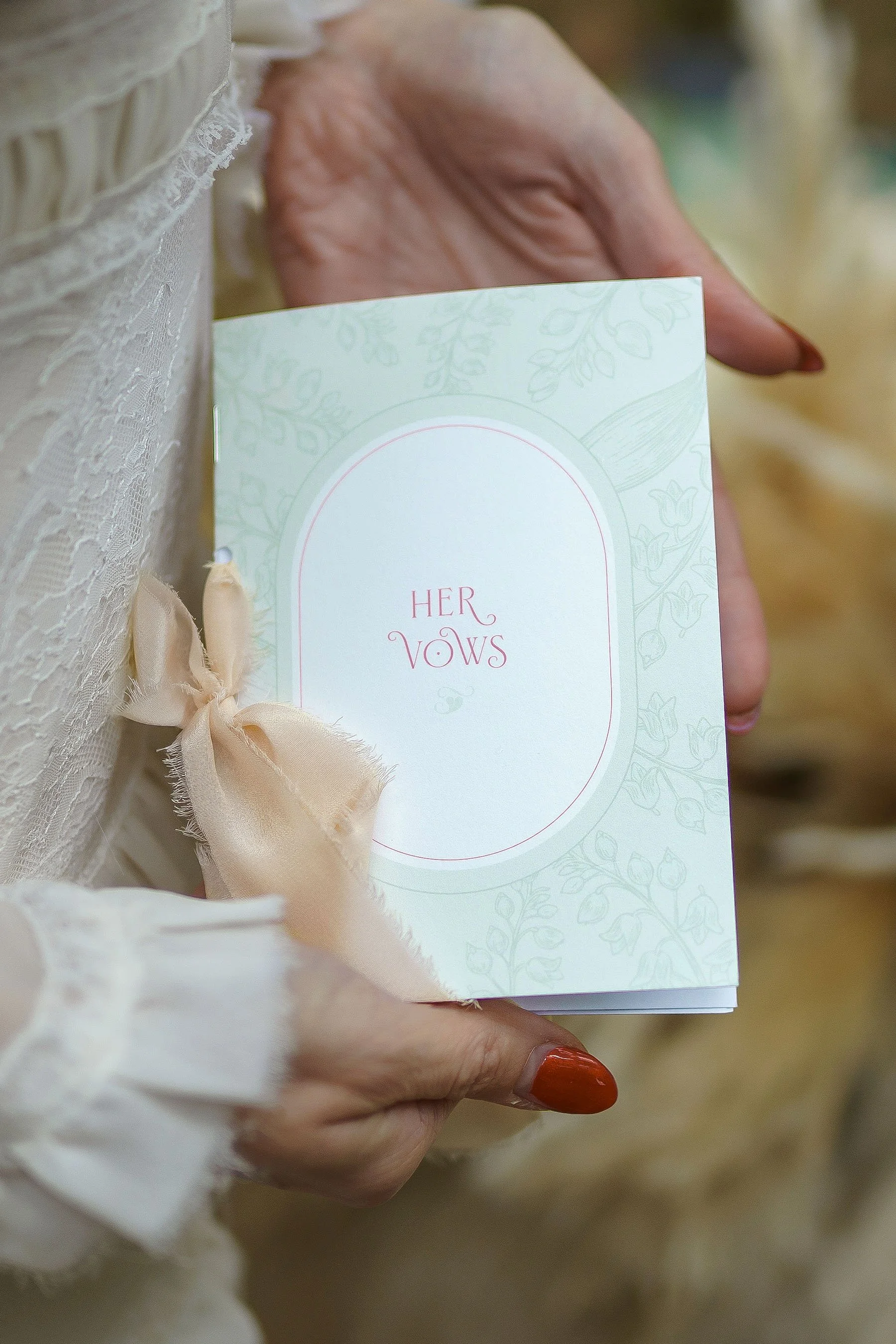 Bride holding Ever Entwined wedding stationery vow books during a woodland wedding editorial.