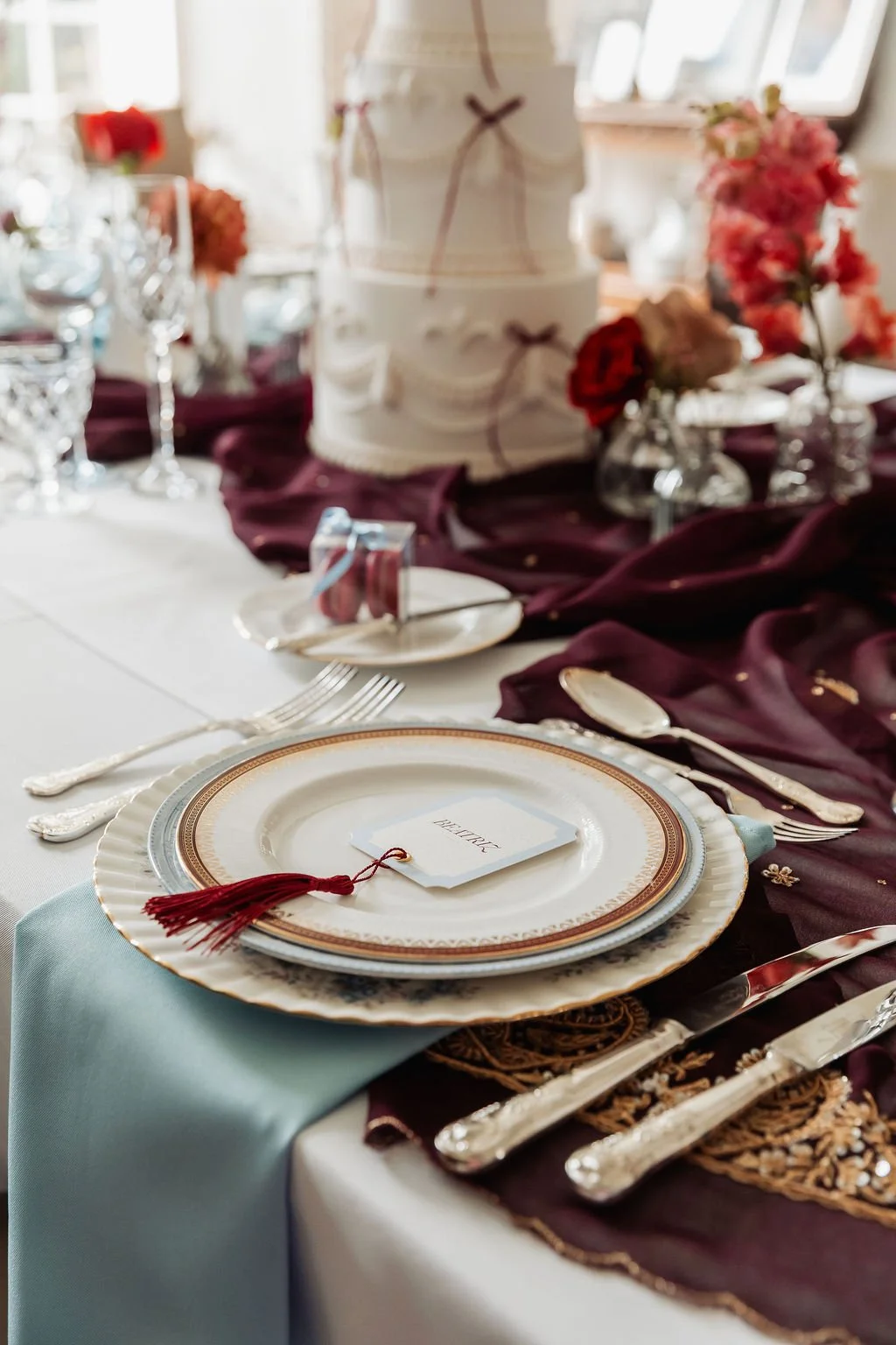 Luxury wedding place cards in ivory and powder blue, adorned with burgundy tassels. Stationery designed by Carrie at Honey Bee Mine, and captured in the Scottish Highlands.