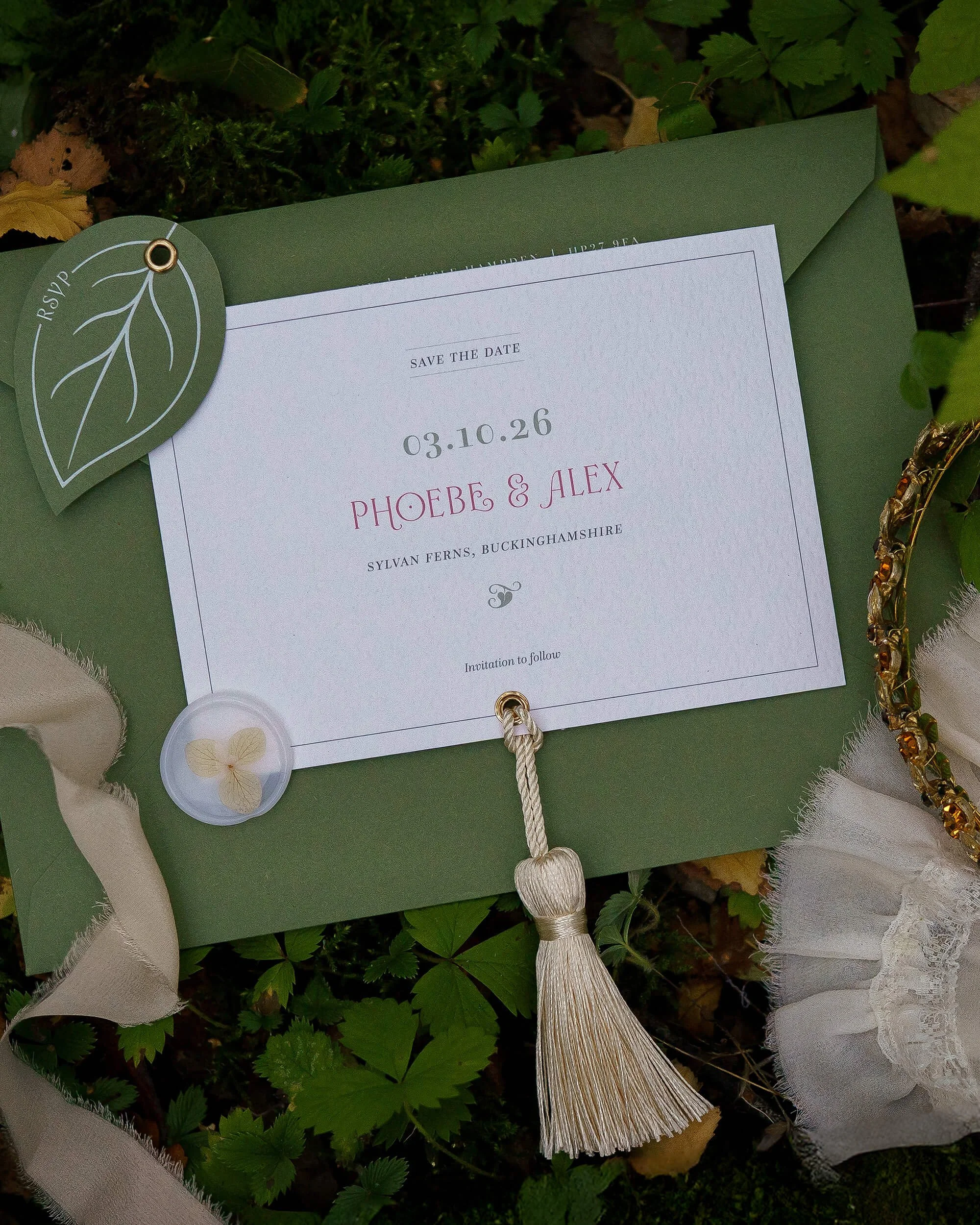 Luxury ivory and forest green wedding invitation suite with botanical details and die-cut shapes.