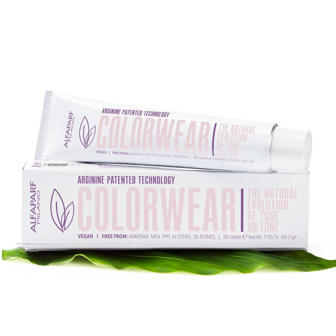 Tube of Colorwear lipstick resting on its packaging box, with a green leaf underneath, featuring purple and pink text and graphics.