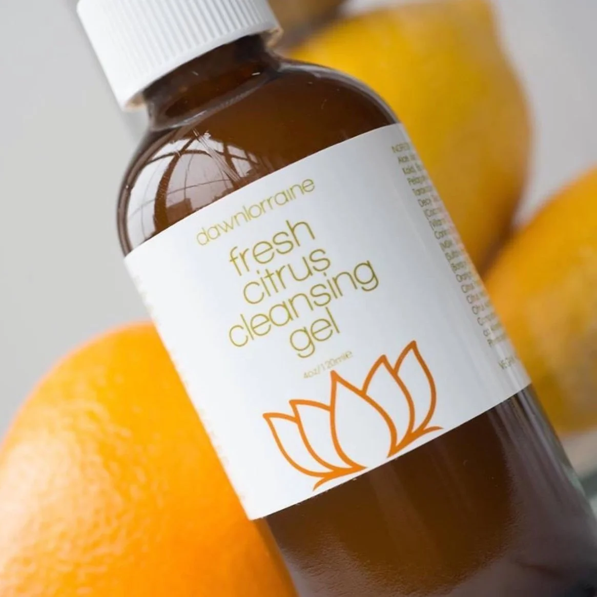 A brown bottle labeled 'Downarea Fresh Citrus Cleansing Gel' with oranges in the background.