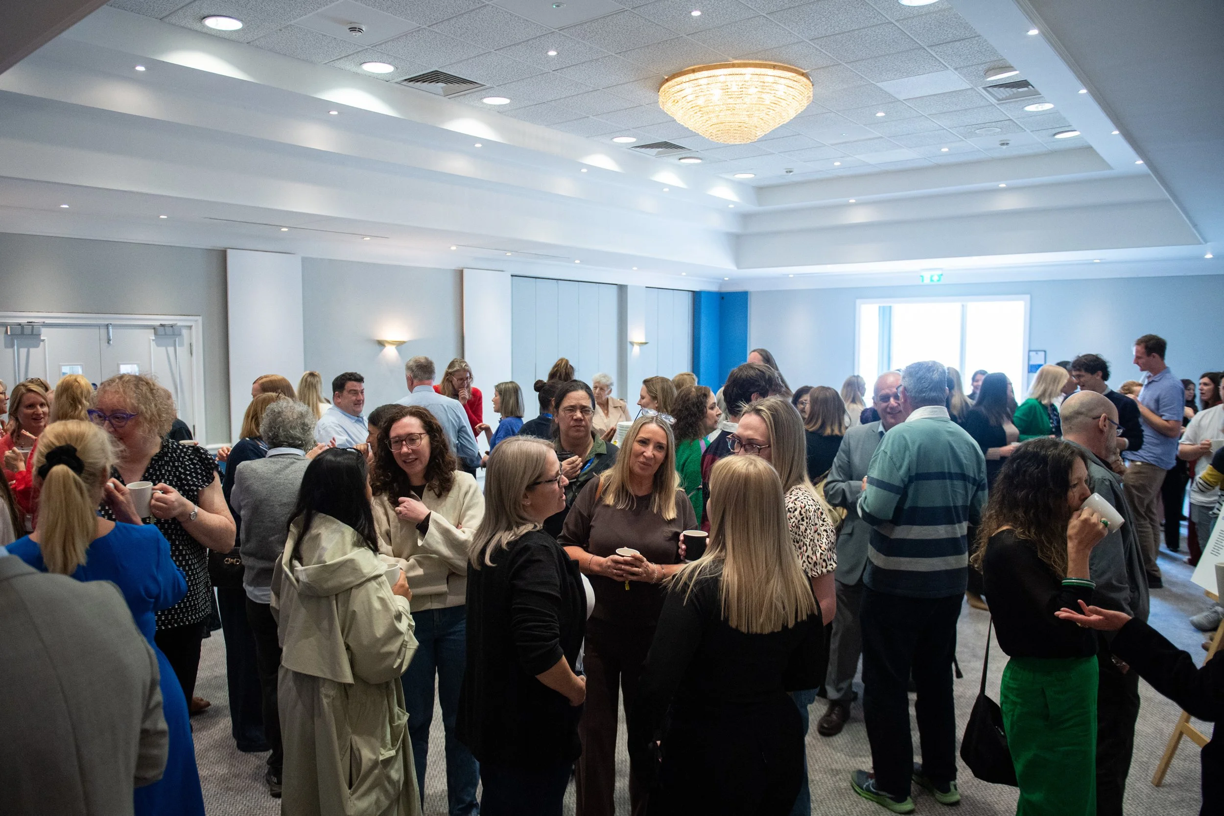 A large group of staff chat during their coffee break