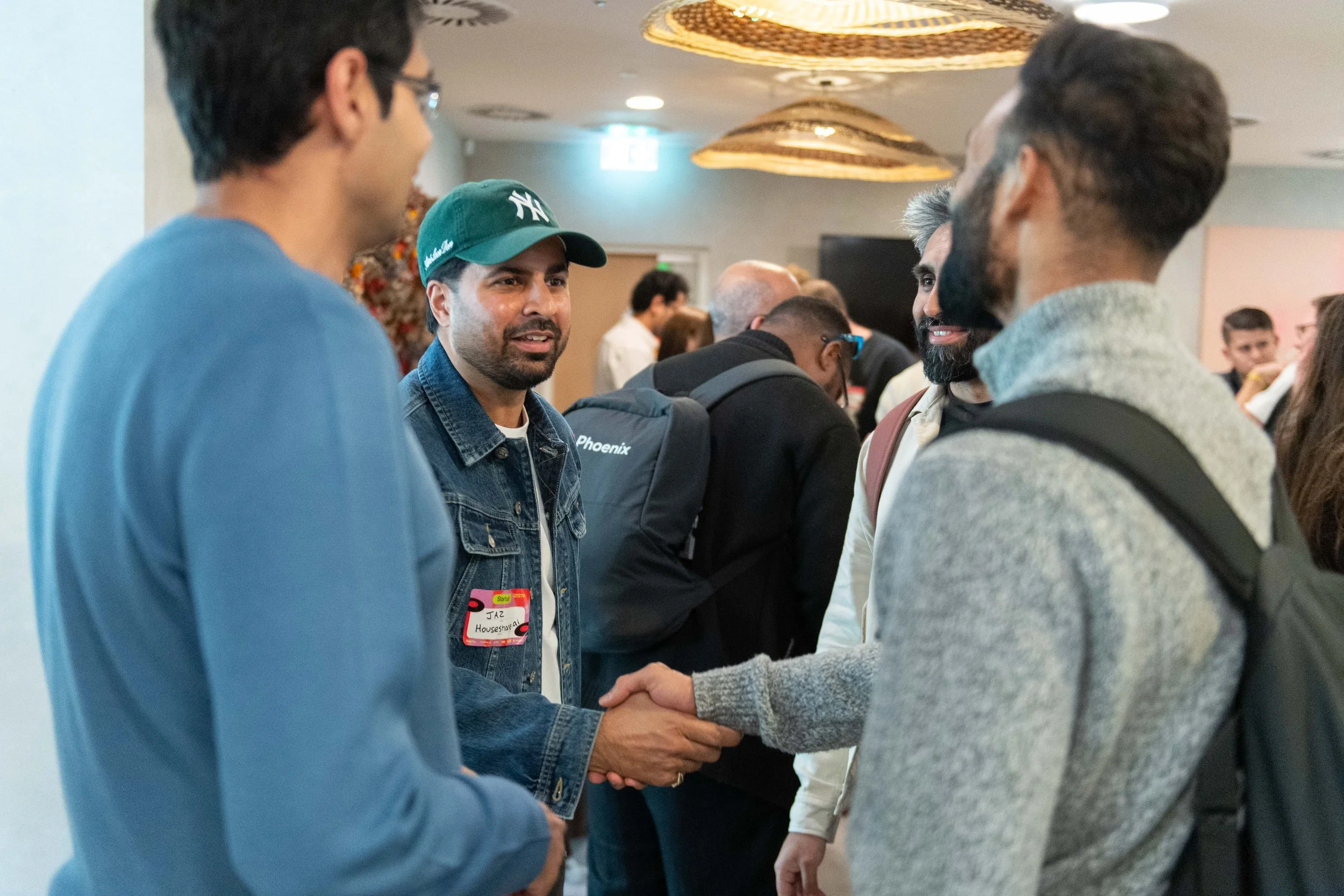 A group of men shake hands and greet each other