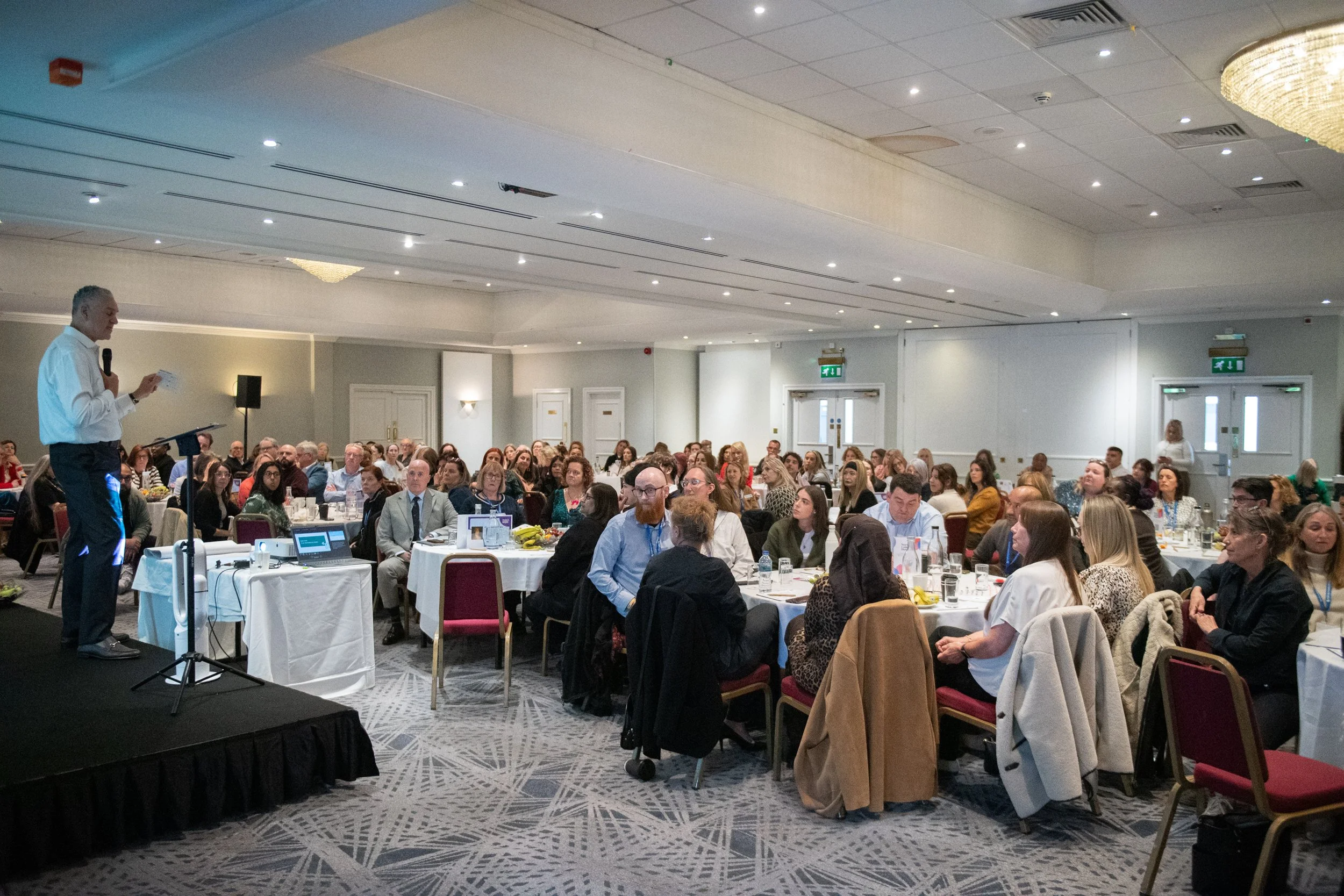 Keynote speaker talking to a large group of conference attendees 
