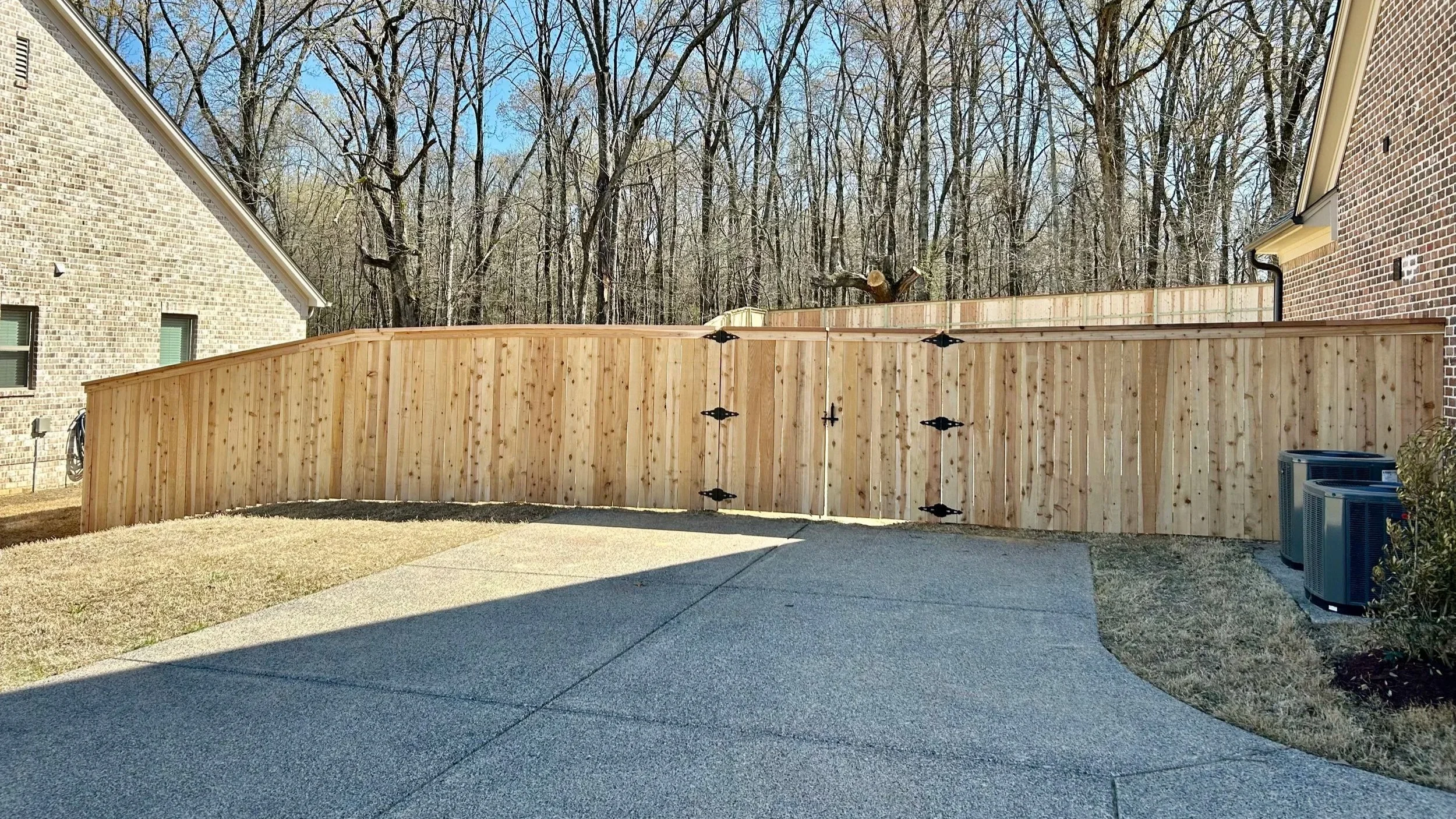 Custom cedar privacy fence with cedar cap and trim installed in Hernando, MS by DeSoto Fence Co.