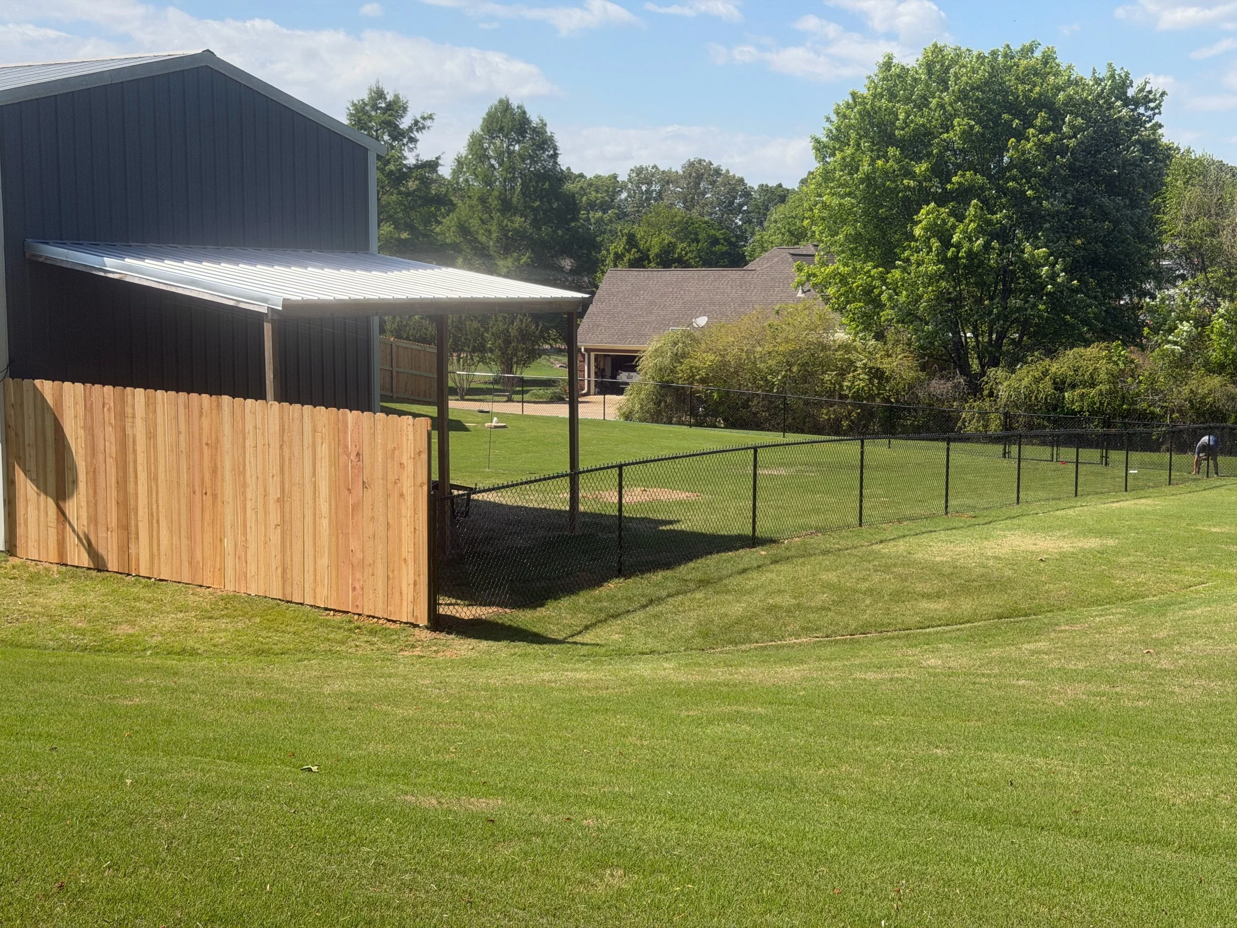 Black chain link fence with cedar privacy sides built in Hernando, MS by DeSoto Fence Co.