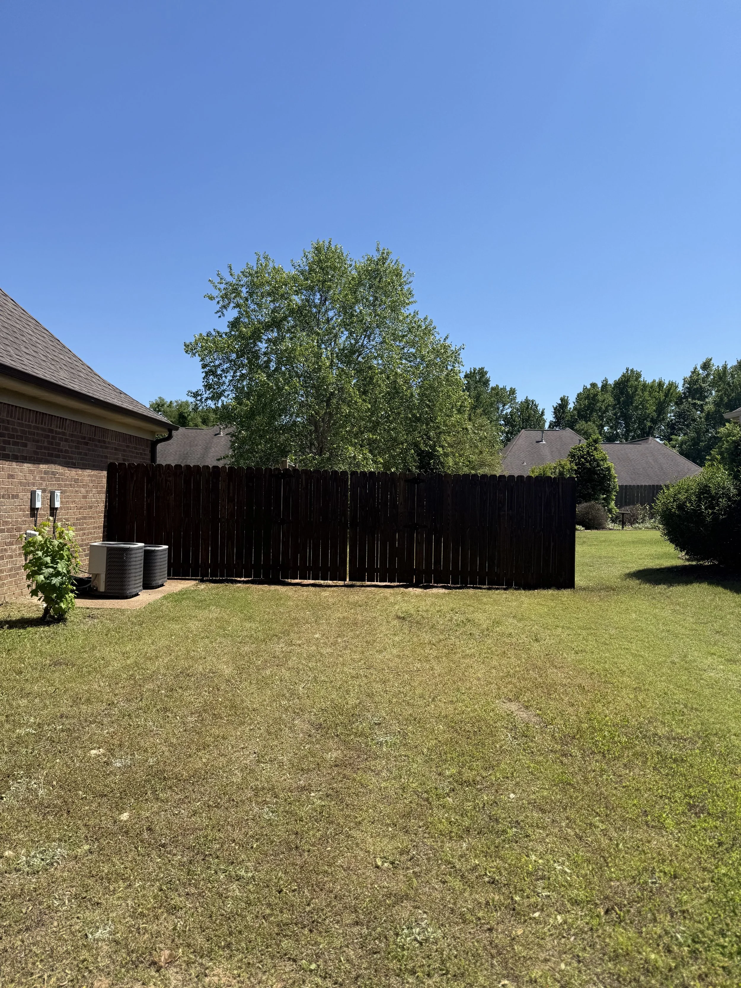Pressure treated pine privacy fence finished with dark walnut stain in Southaven, MS by DeSoto Fence Co.