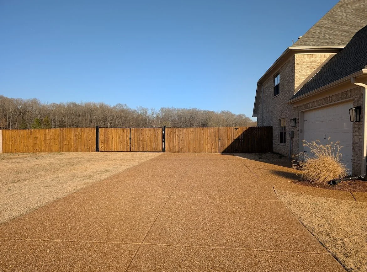 Double cedar driveway gate with welded steel frames installed as part of a residential privacy fence in Hernando, Mississippi by DeSoto Fence Co.