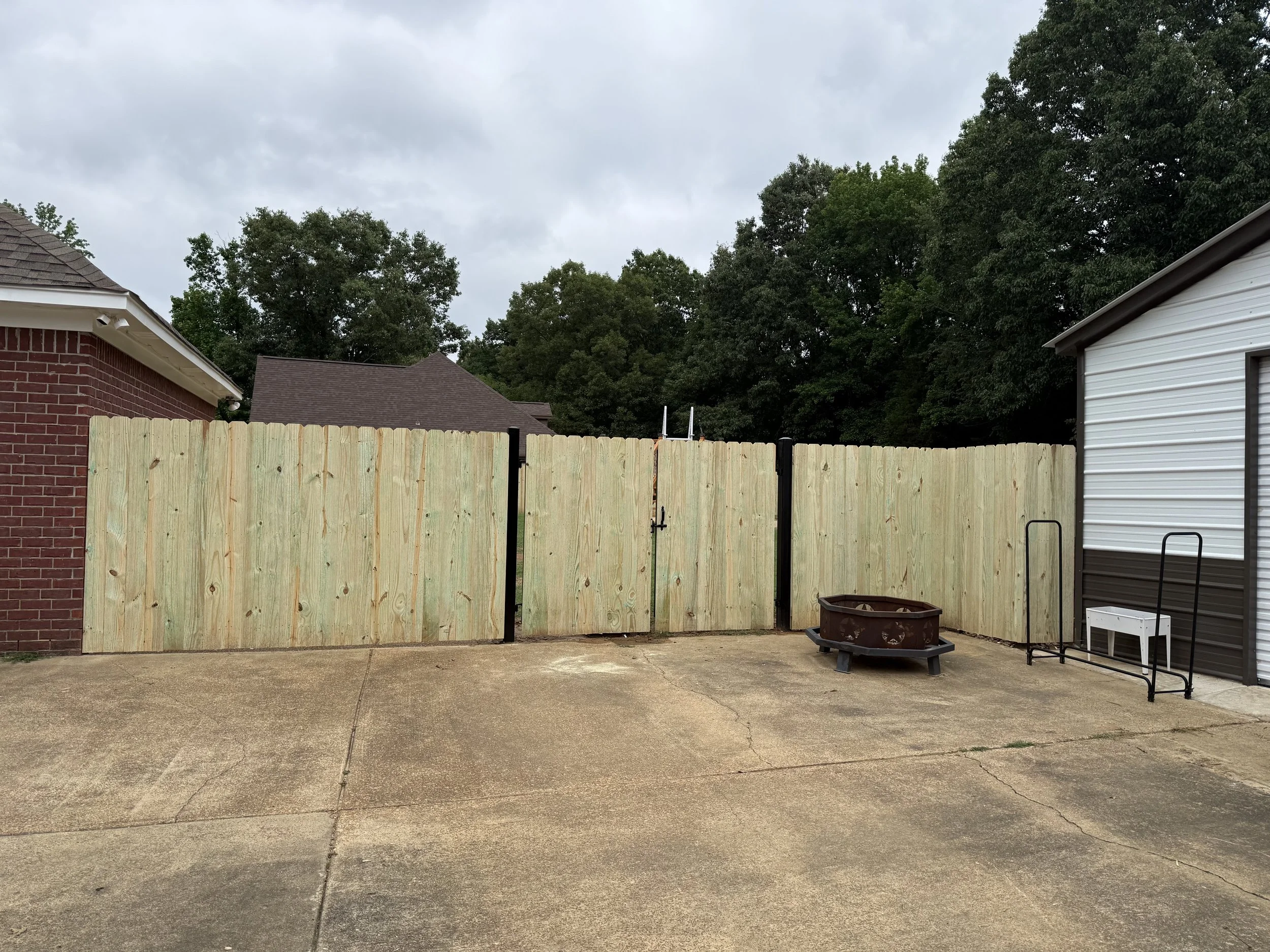 Pressure treated pine privacy fence with custom double steel frame gates front view installed in Hernando, MS by DeSoto Fence Co.