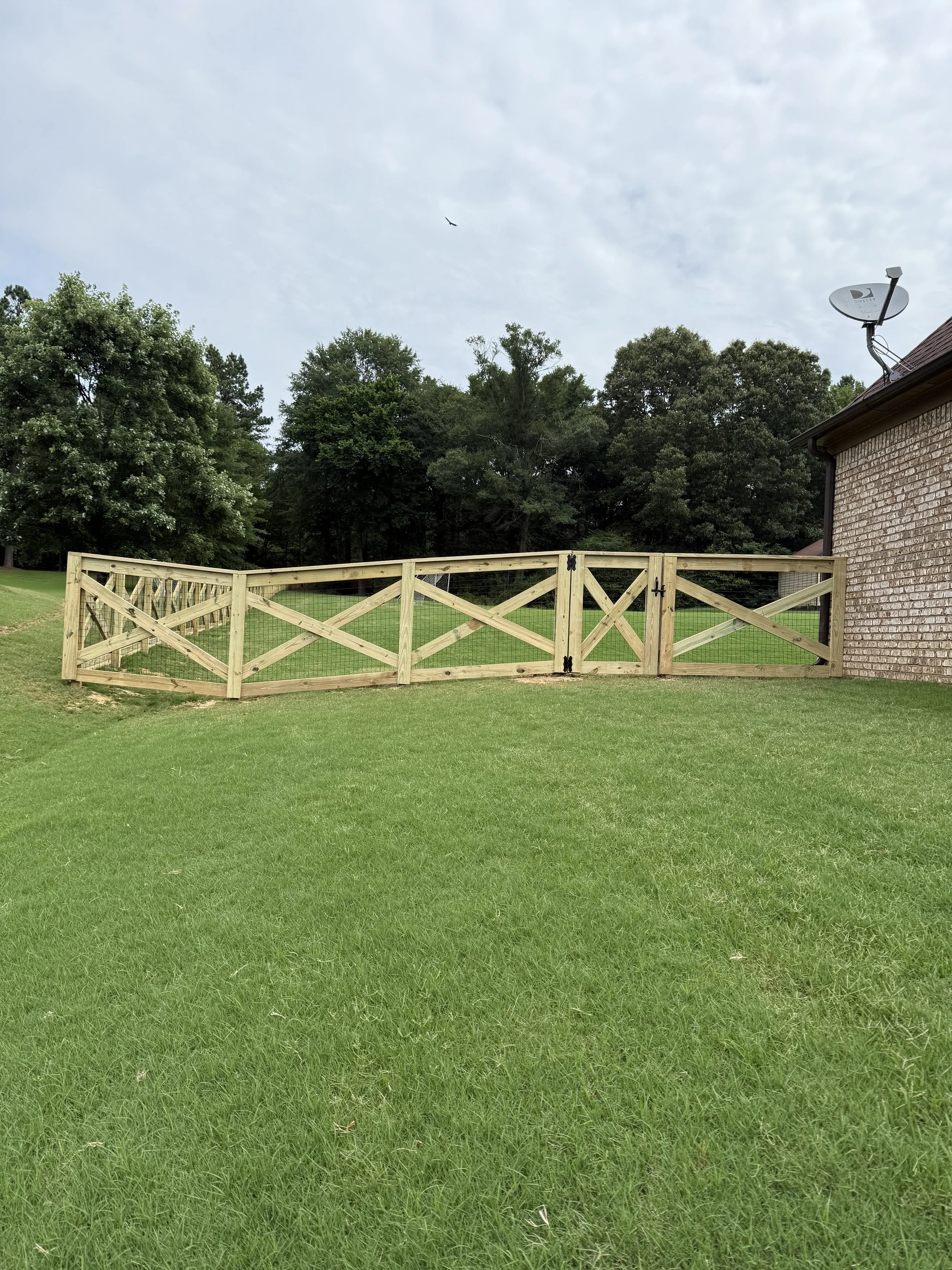 Custom crossbuck walk gate with matching welded wire fencing installed around a residential property in Olive Branch, Mississippi by DeSoto Fence Co.