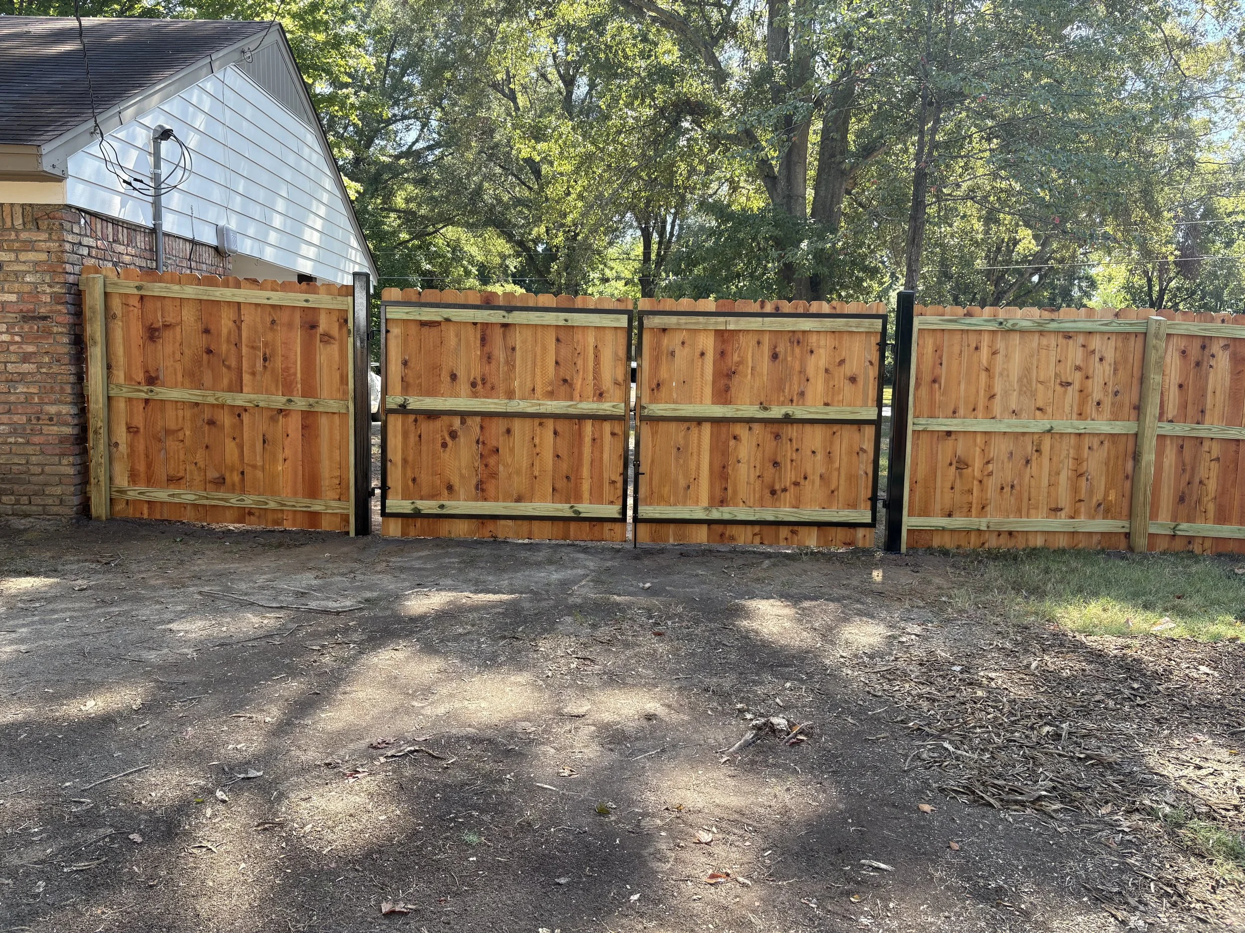 Rear view of a custom double cedar driveway gate with welded steel frames installed in Hernando, Mississippi by DeSoto Fence Co.