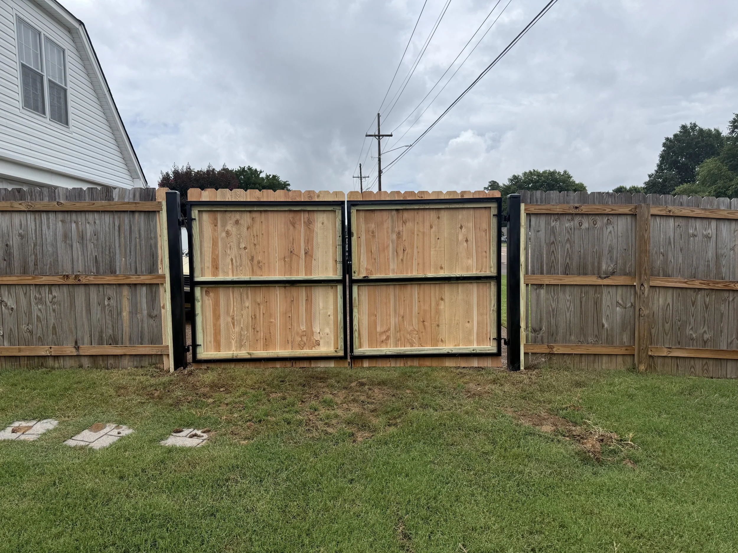 Custom double metal frame gate with premium cedar privacy pickets installed in Southaven, MS. Built for strength, durability, and a seamless match with the surrounding cedar privacy fence, providing secure driveway access with a natural wood appearan