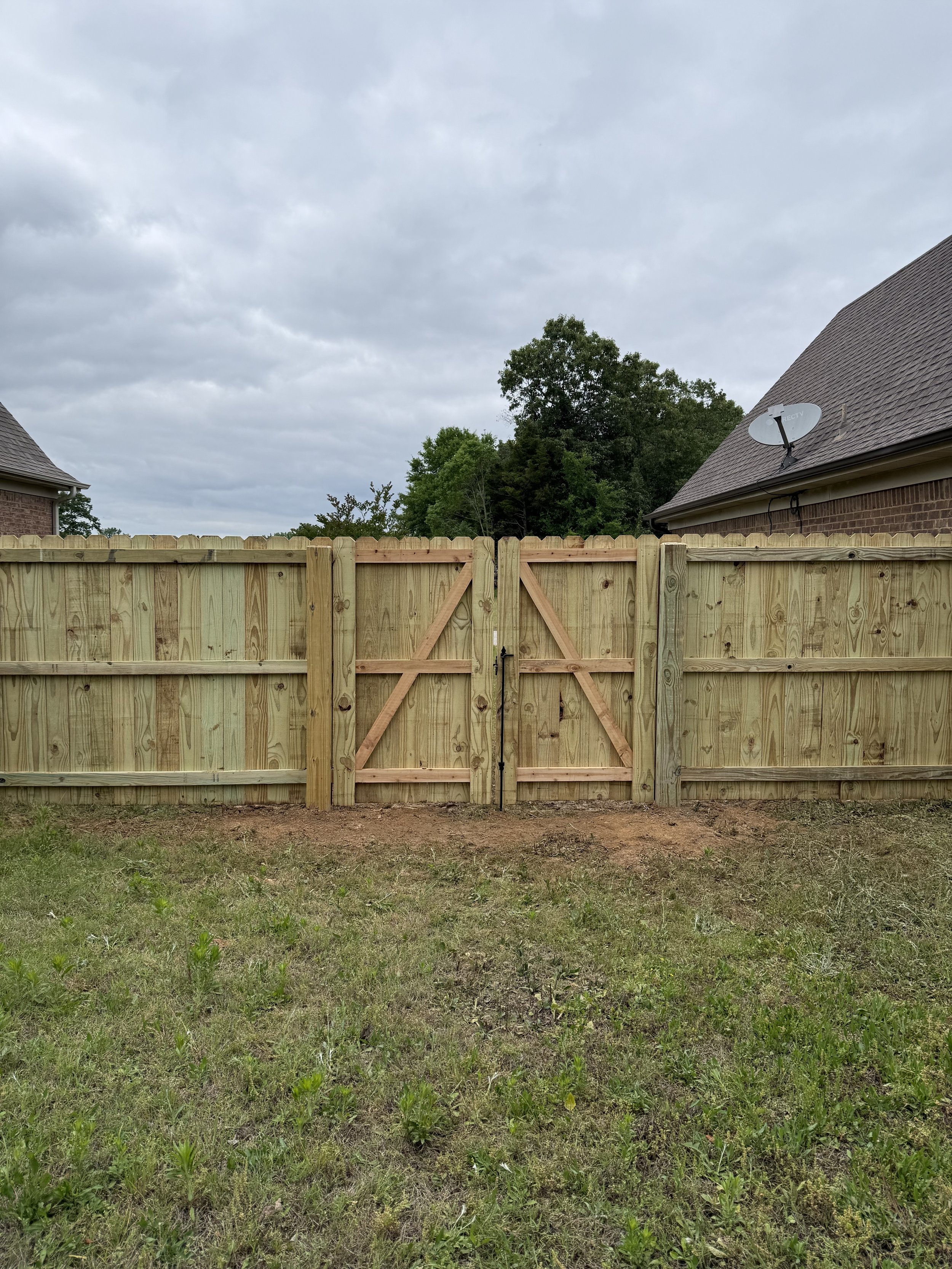 Pressure treated pine privacy fence with custom double cedar frame gates installed in Southaven, MS by DeSoto Fence Co.