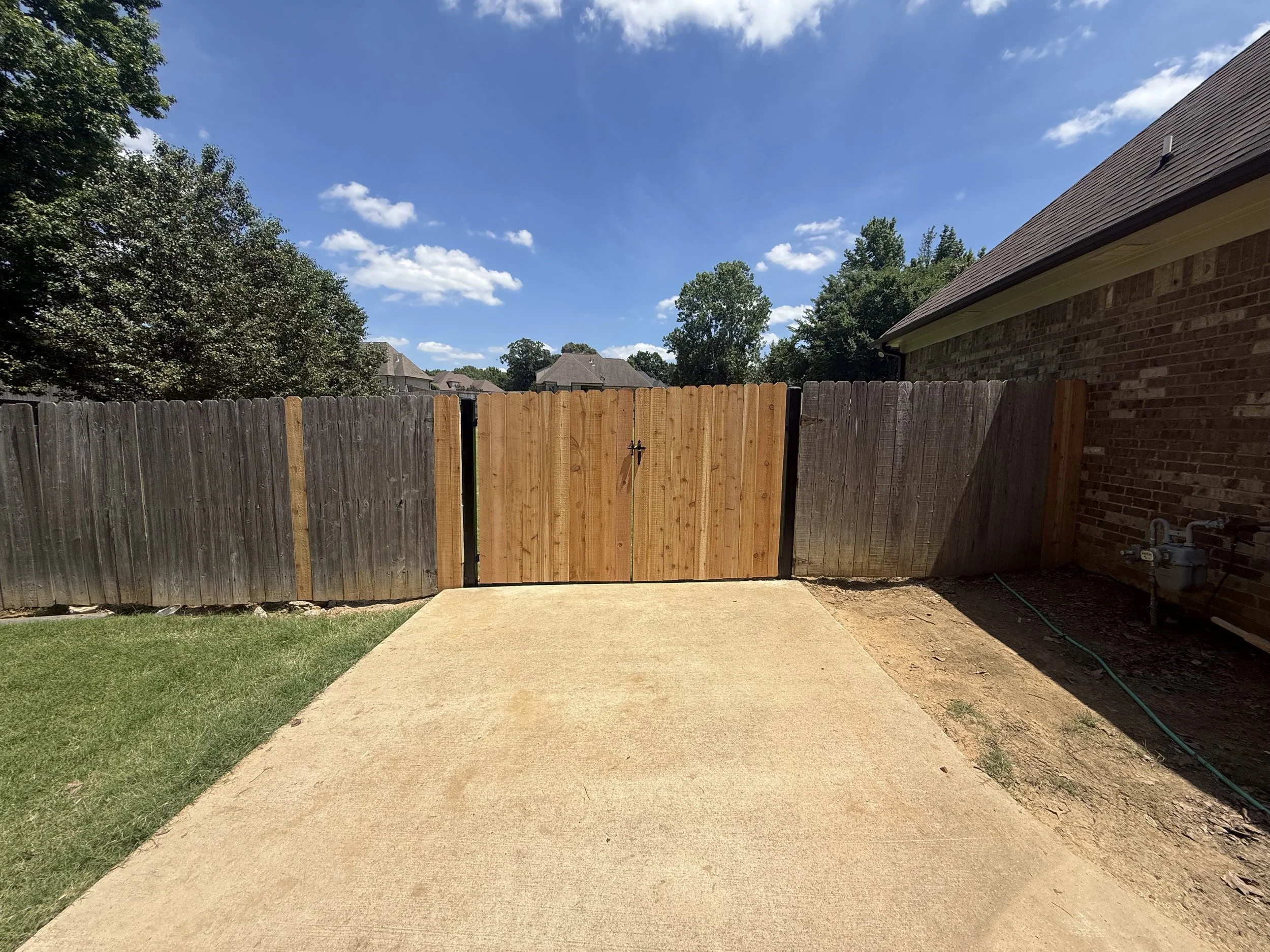 Steel frame cedar privacy gate installation in Hernando, MS featuring premium cedar pickets for a strong, sag-resistant gate with a natural wood finish.
