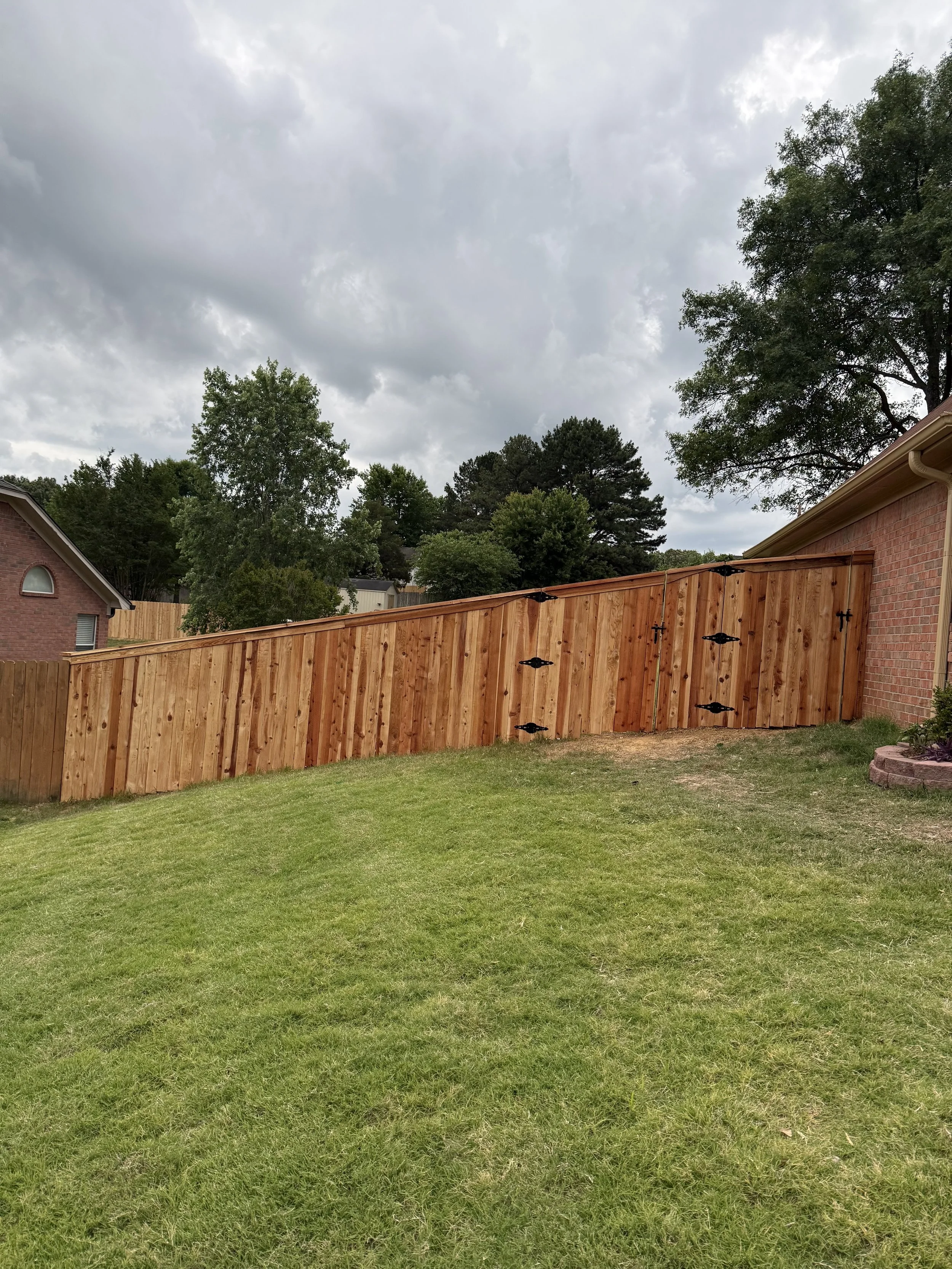 Custom cedar privacy fence with cedar cap and trim and matching gate installed in Olive Branch, MS by DeSoto Fence Co.